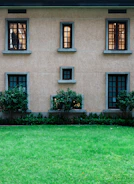 Building wall with windows and green grass