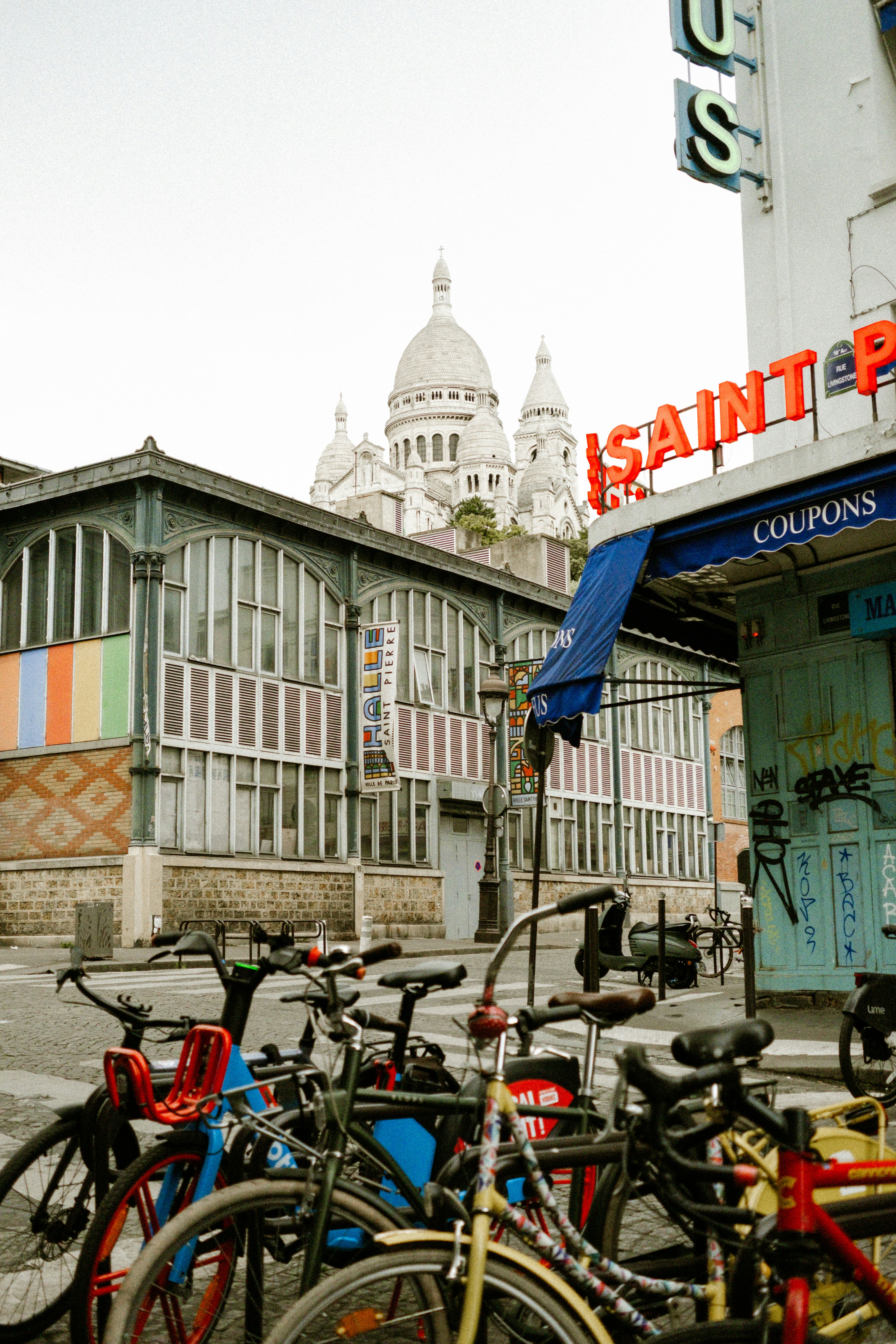 Sacré-cœur basilica visible behind parked bicycles on a parisian street.
