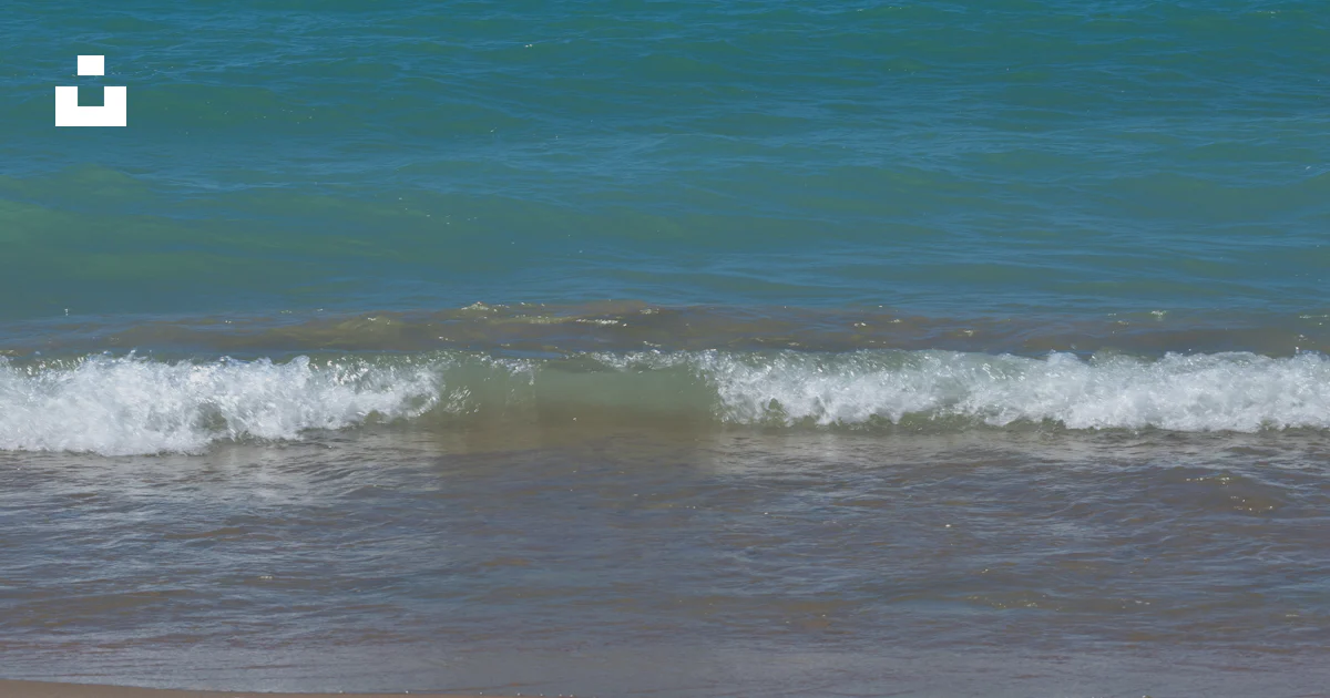 Stack Lakeshore Las olas turquesas del océano se encuentran con una playa de arena bajo ...