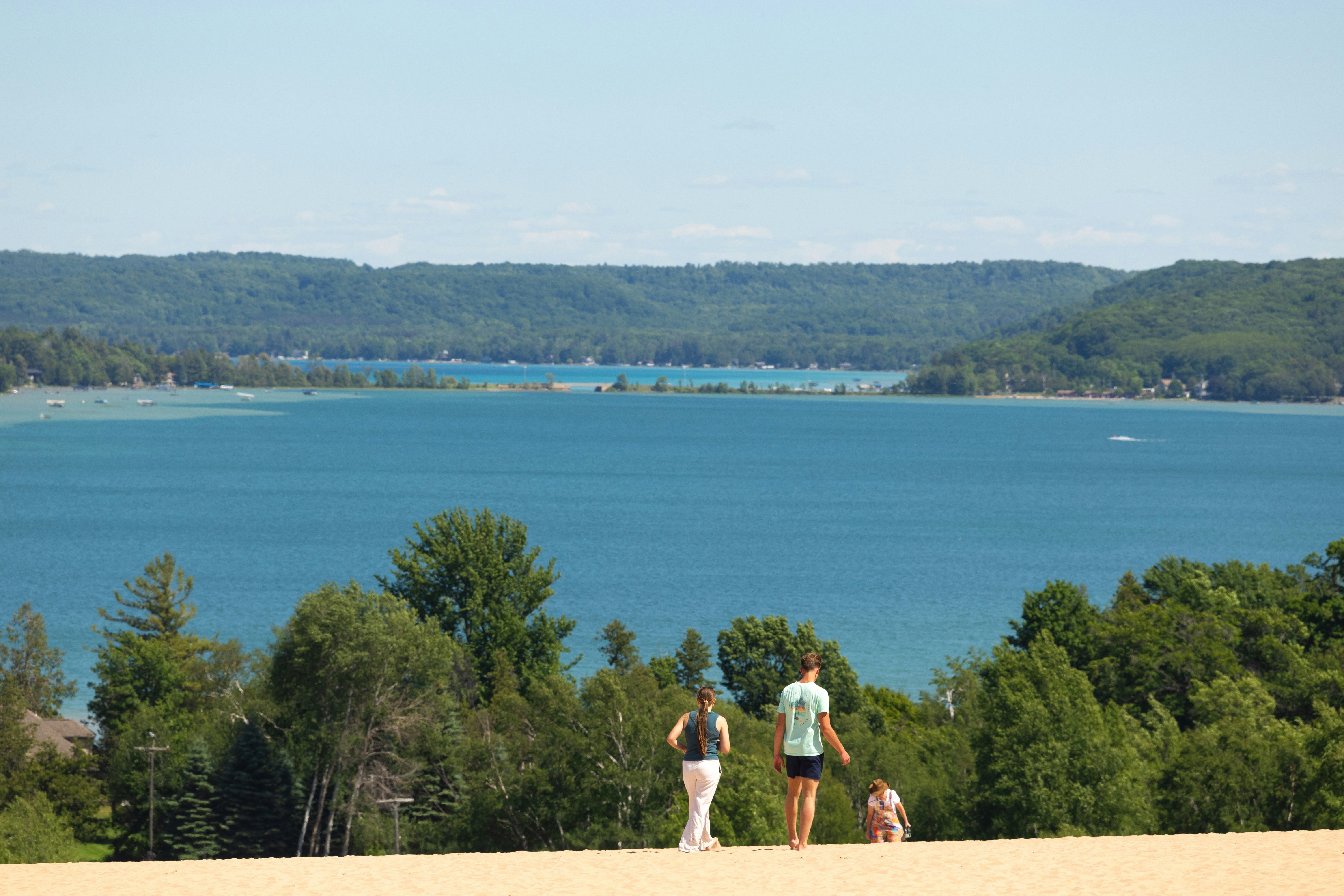 Gente en una duna de arena con vistas a un gran lago azul - Foto ...