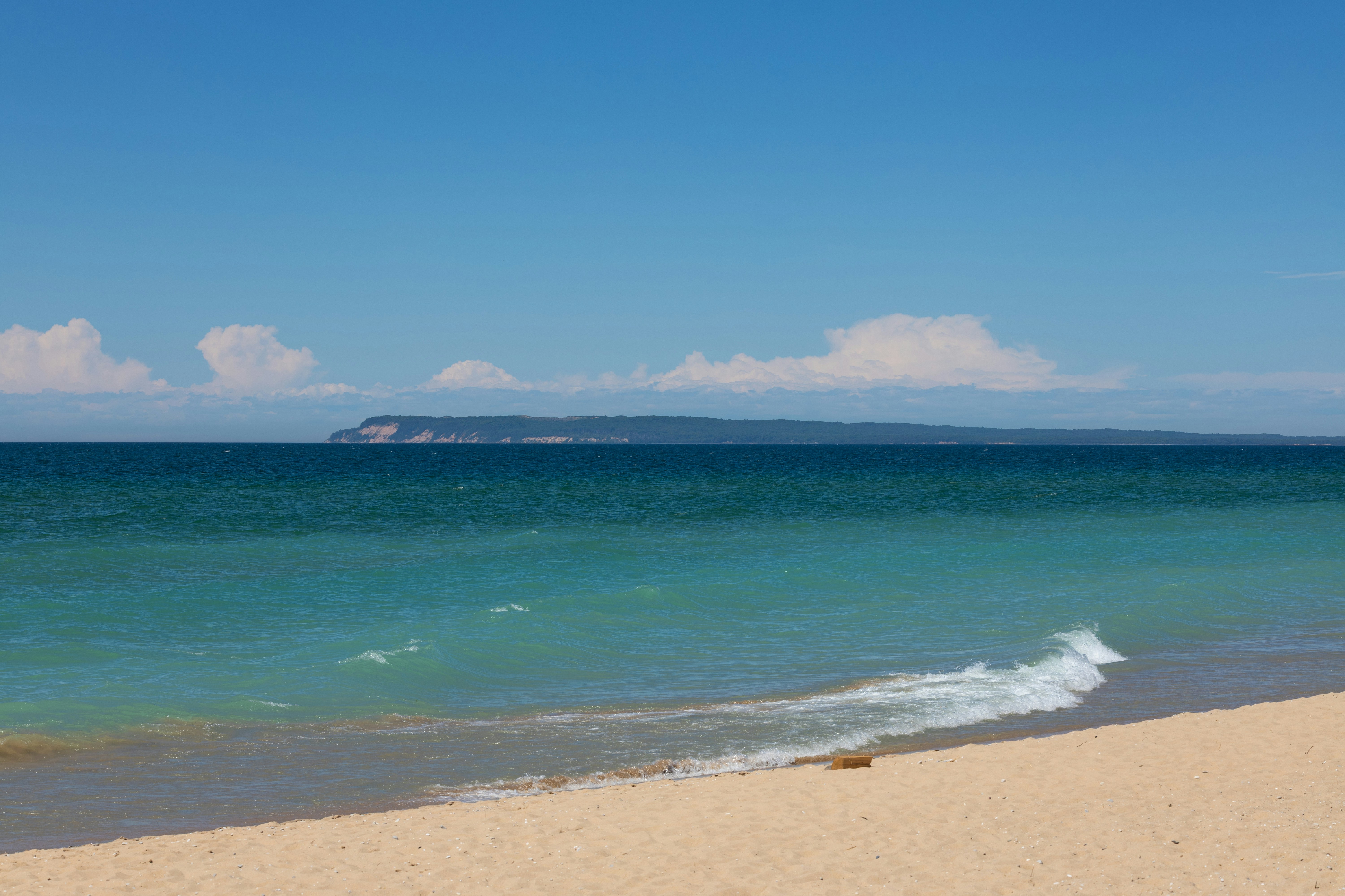 Agua turquesa en una playa de arena con una isla lejana - Foto gratuita ...