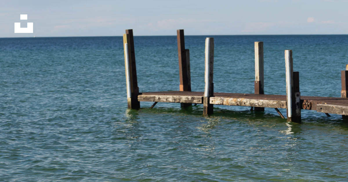 Stack Lakeshore Antiguos postes de muelle de madera se alzan en aguas claras del lago ...