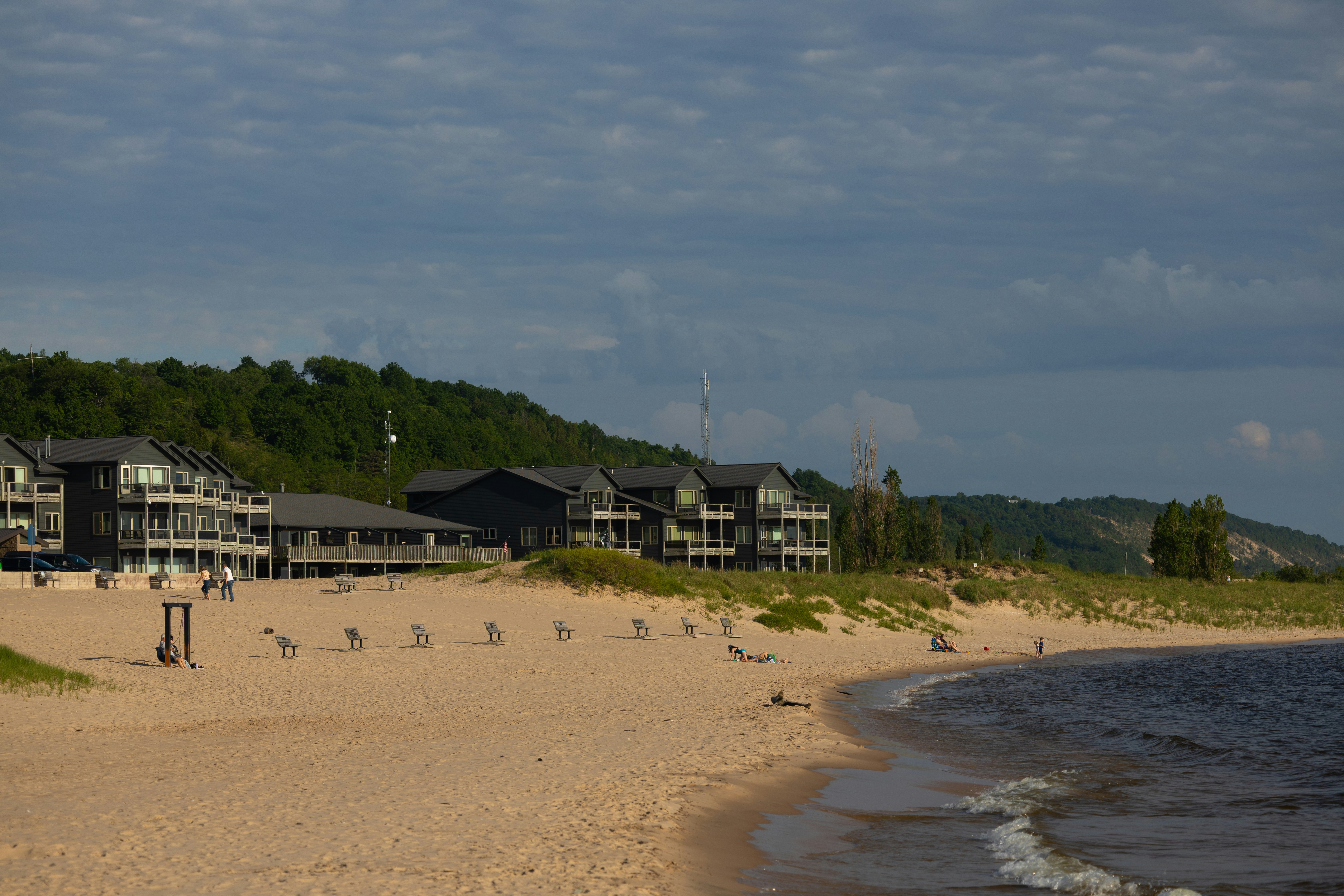 Sandy beach with resort buildings and green hills