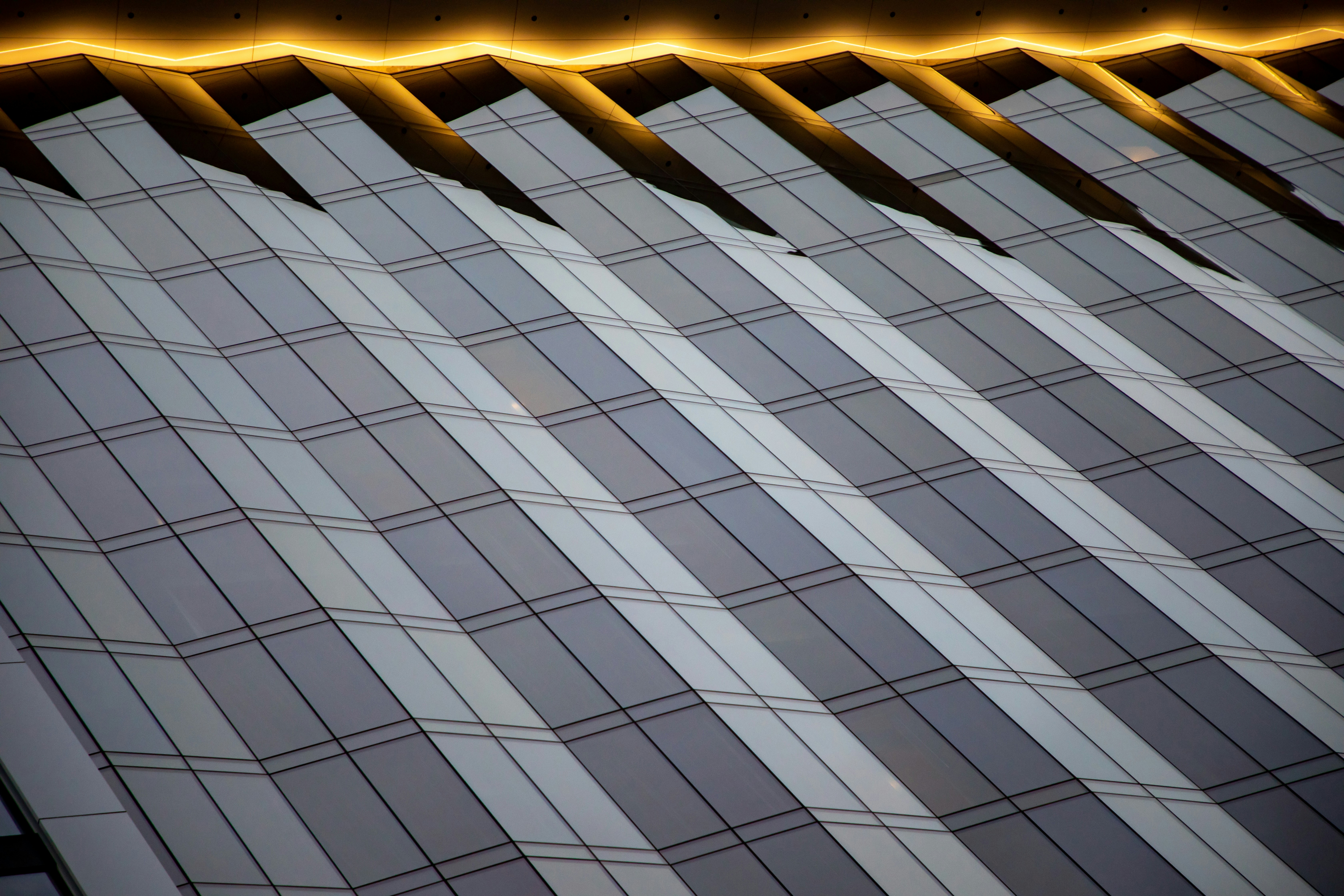 Fachada moderna con cristal reflectante y luz naranja brillante