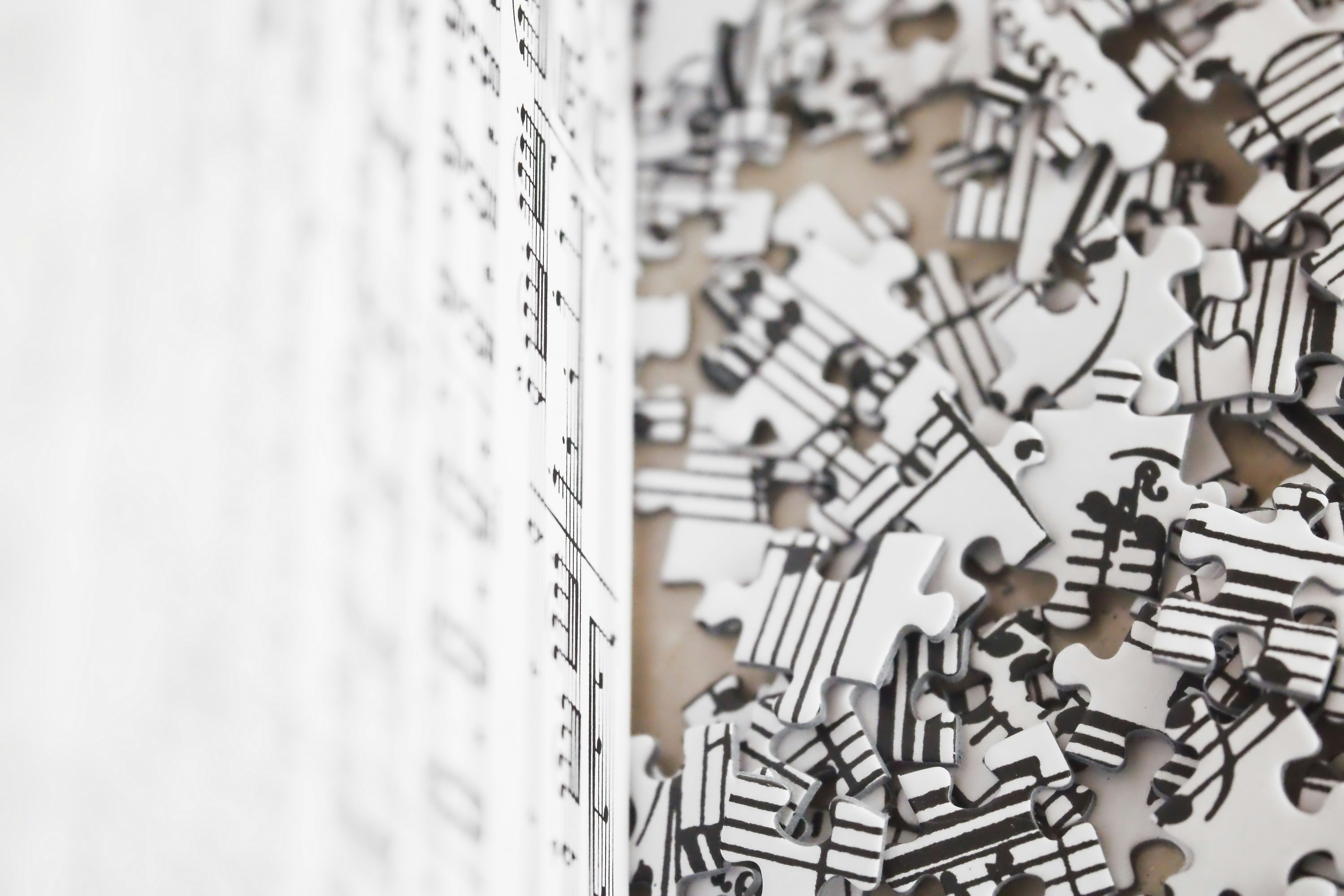 A puzzle with musical notes, some pieces assembled, many scattered