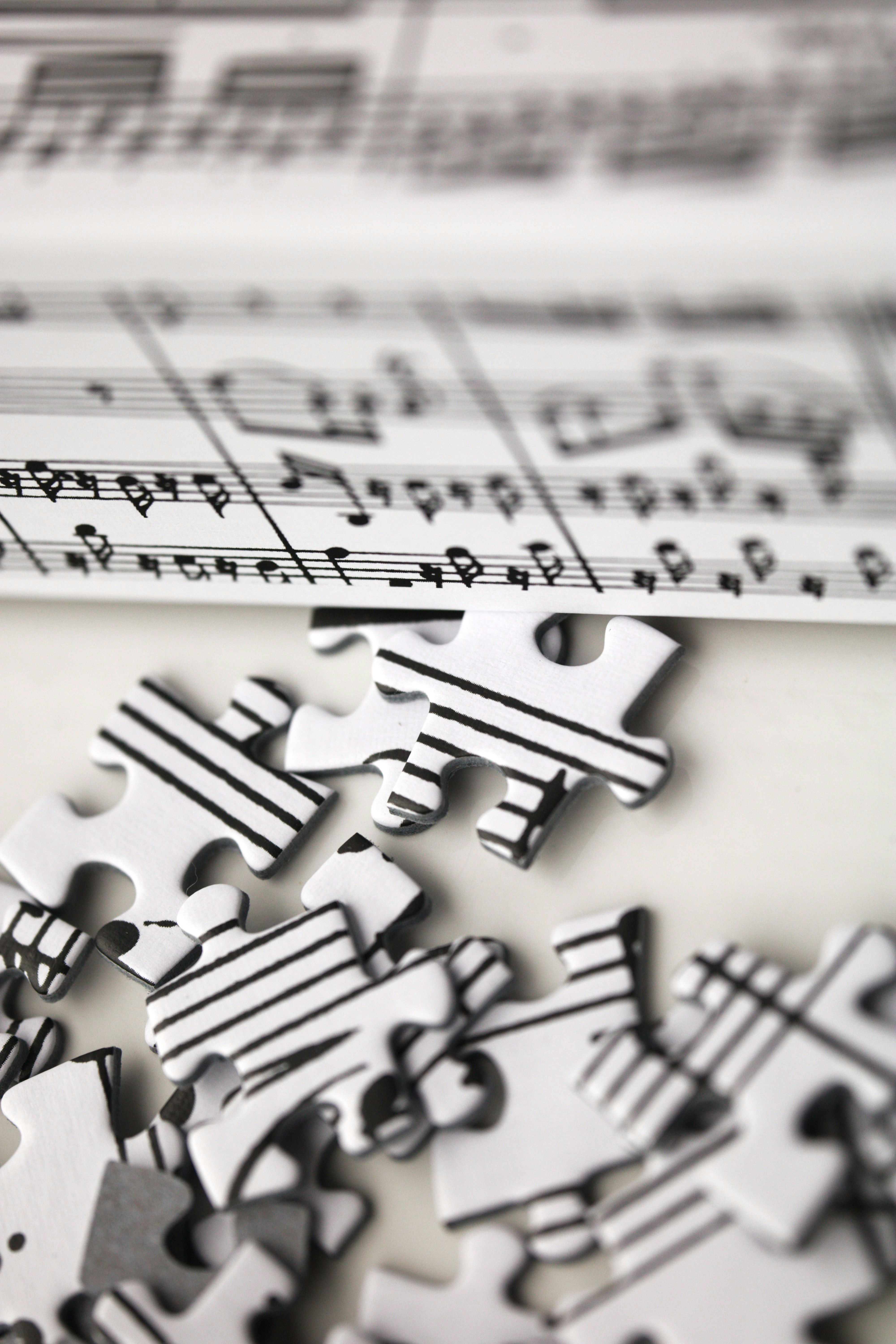 Music notes printed on puzzle pieces, some scattered