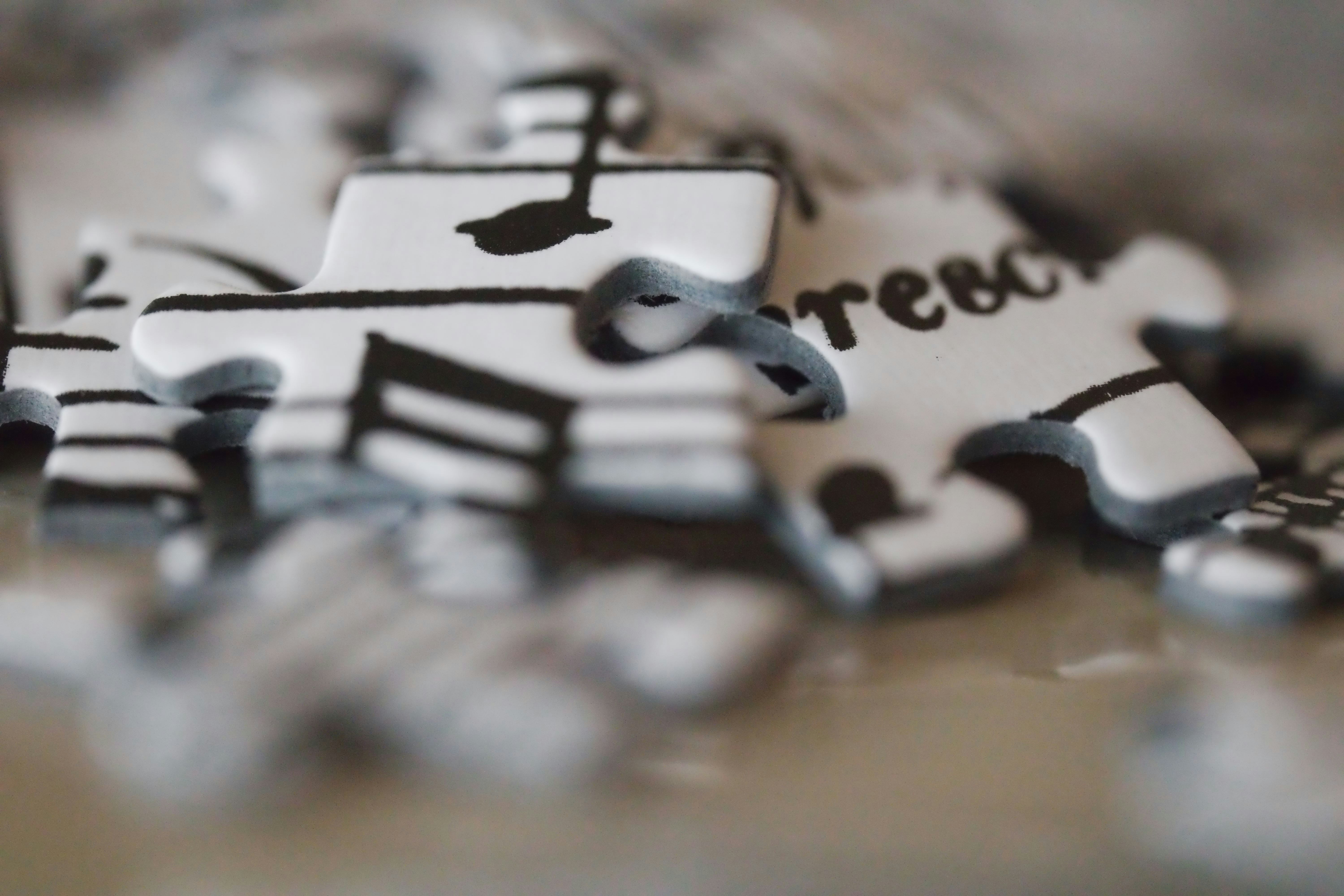 White puzzle pieces depicting musical notes and text