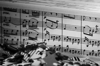 Black and white sheet music with scattered puzzle pieces