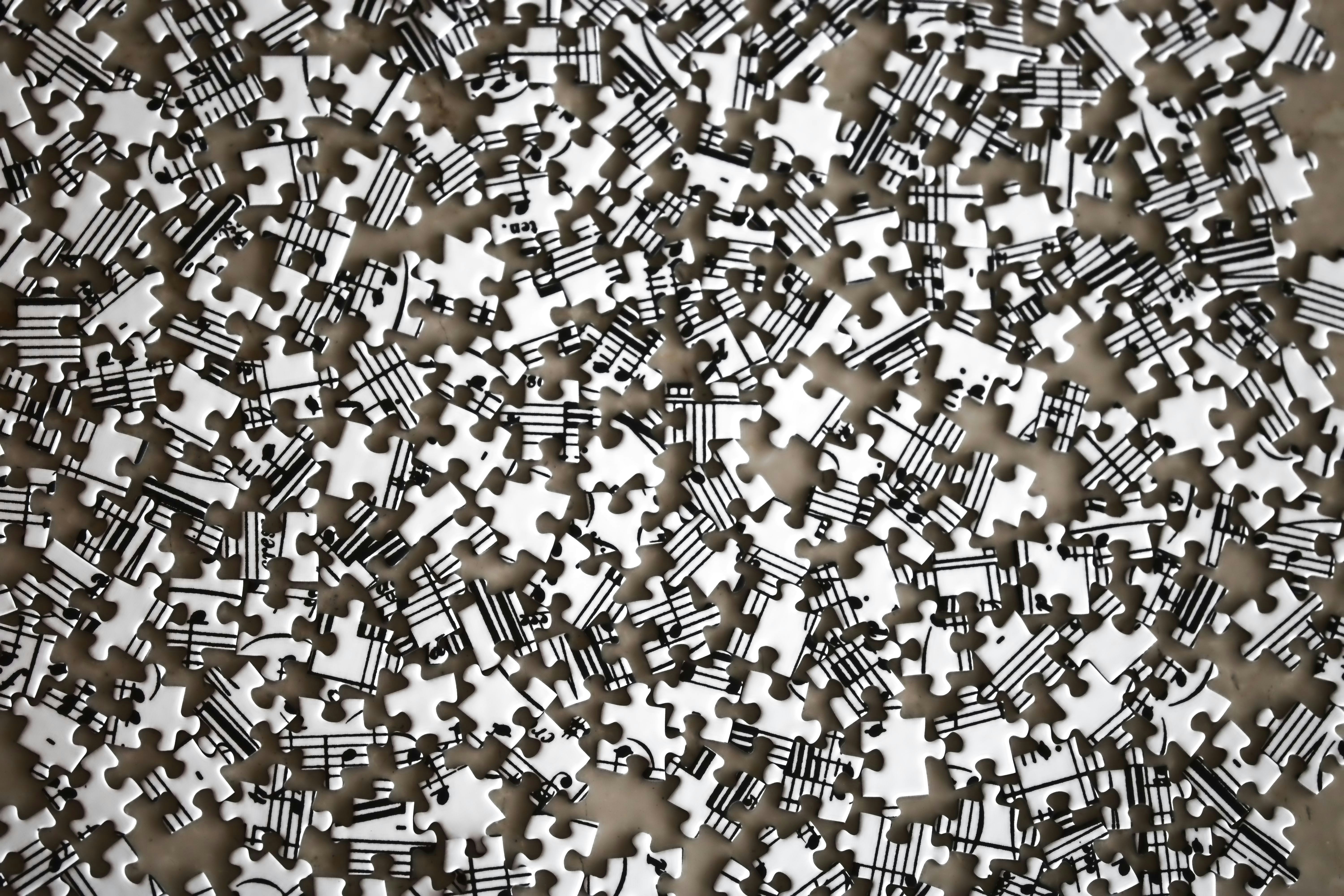 A large pile of scattered white jigsaw puzzle pieces