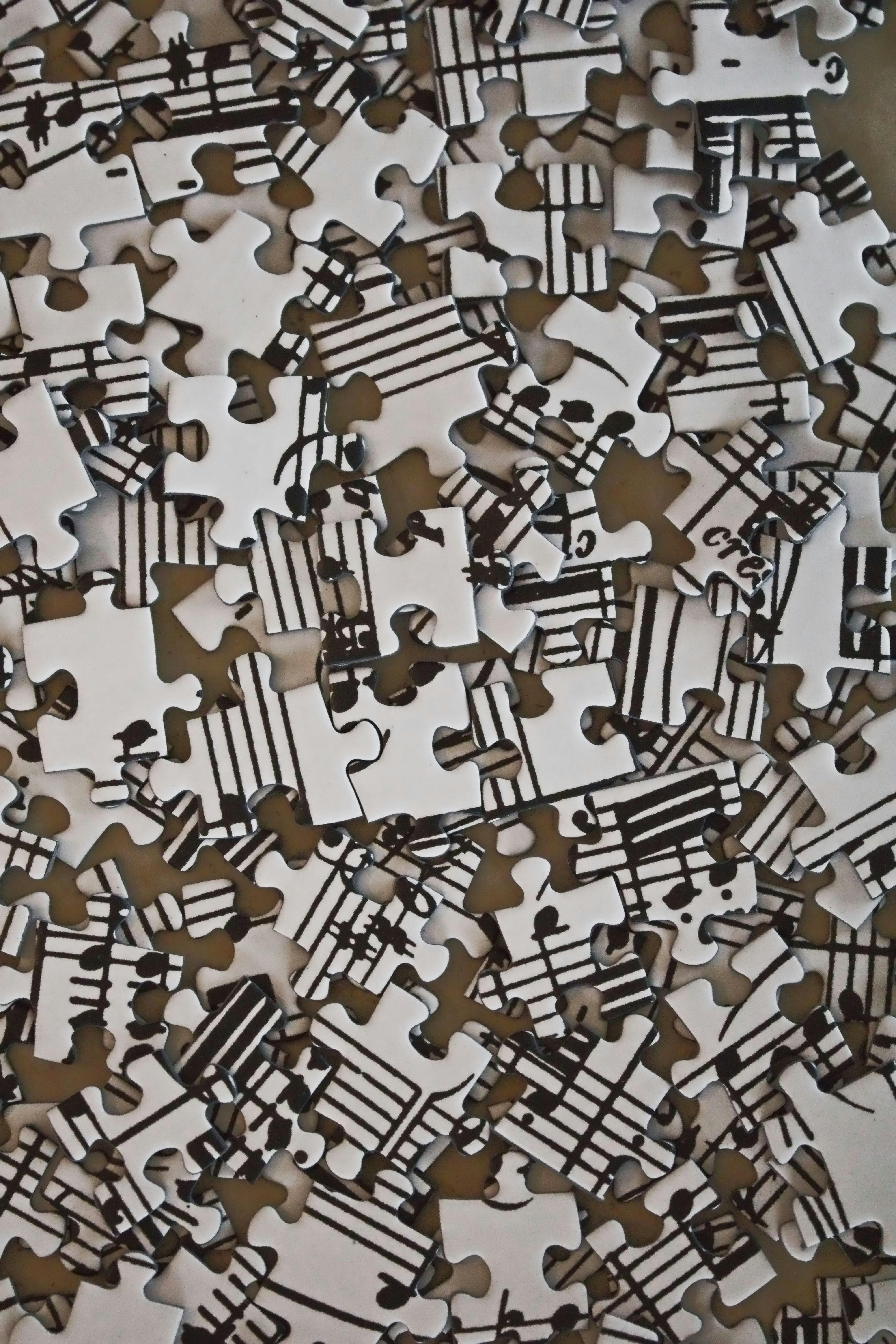 Scattered white puzzle pieces featuring musical notes and staves