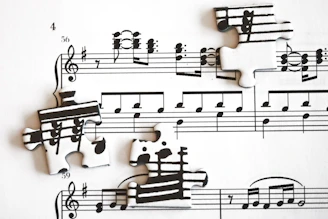 Scattered puzzle pieces with musical notes on sheet music