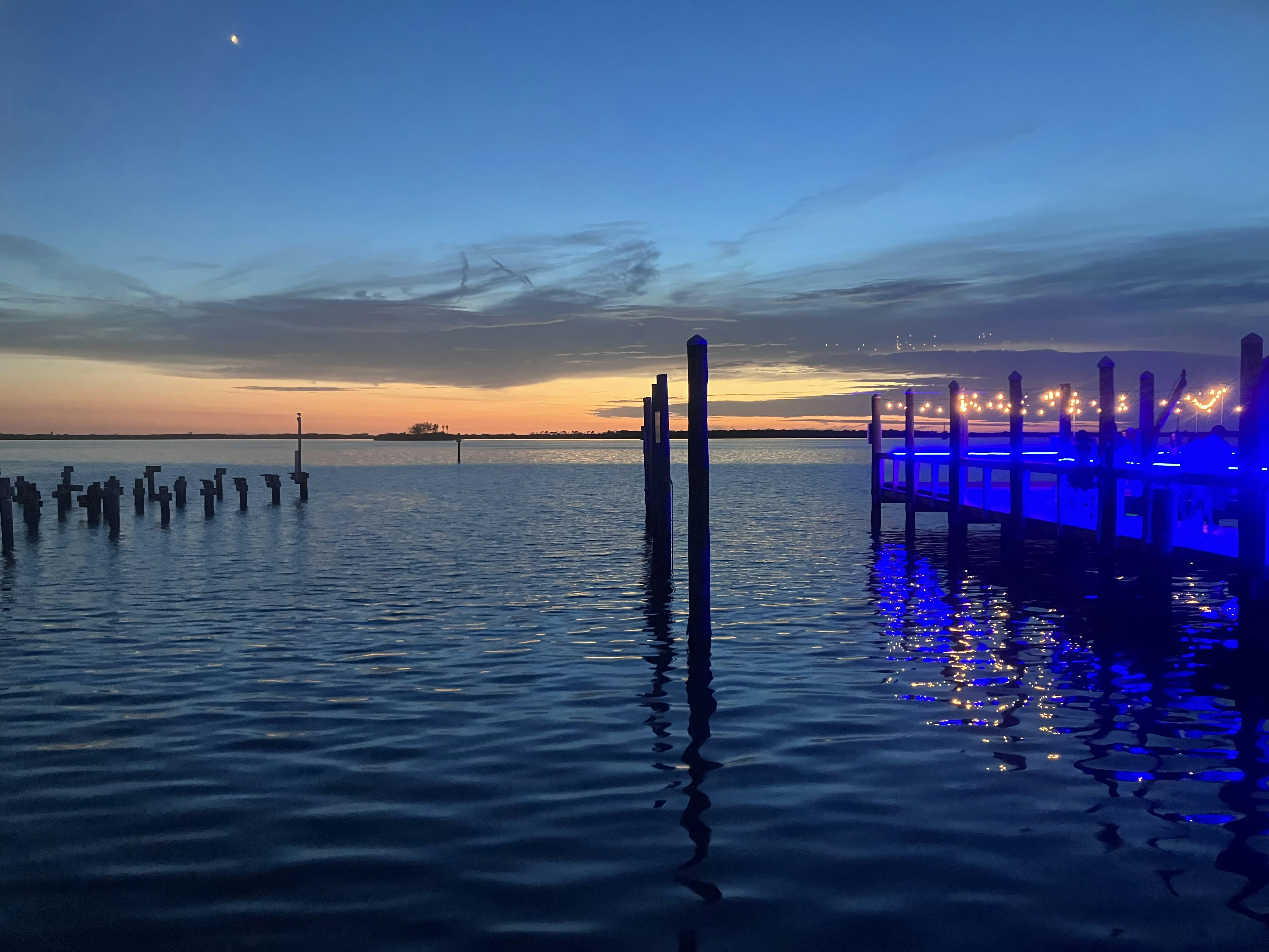 Blue lit dock and pilings at dusk over calm water