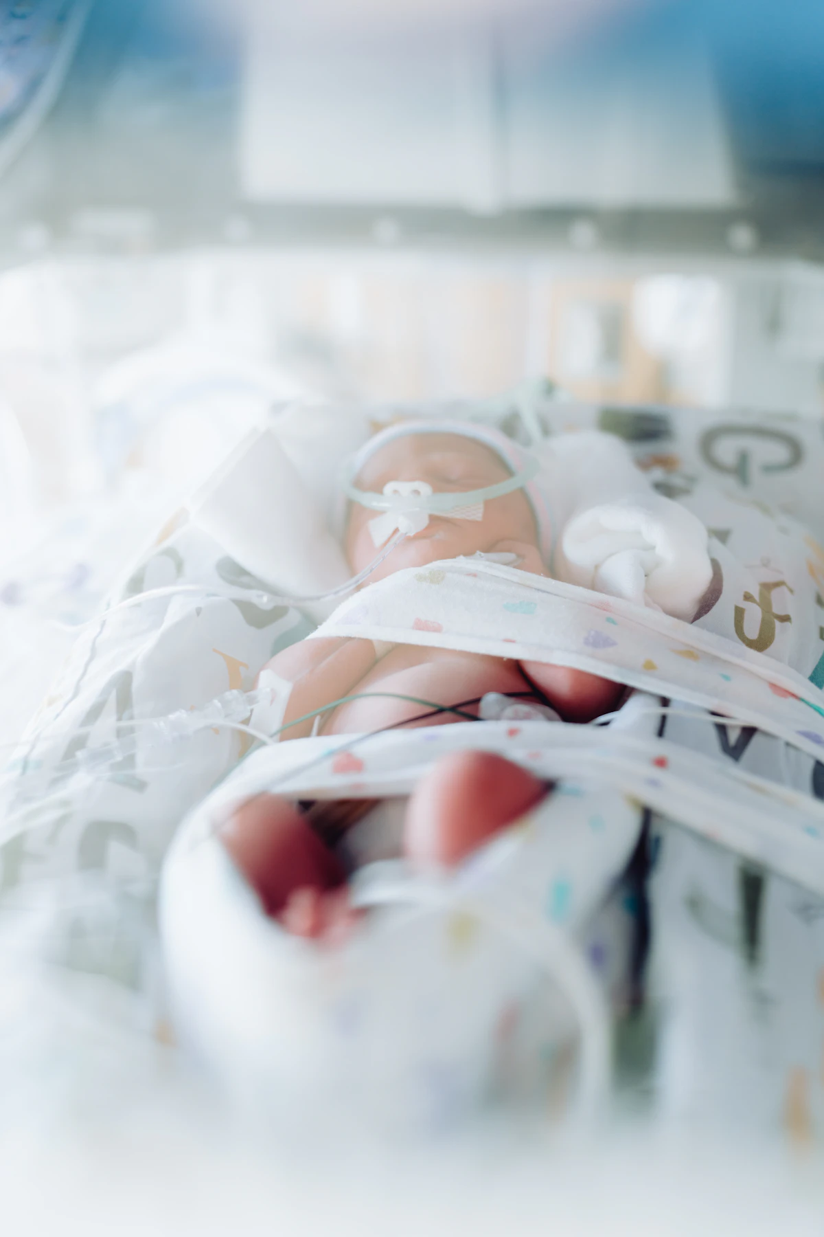 Premature baby in an incubator with medical tubes