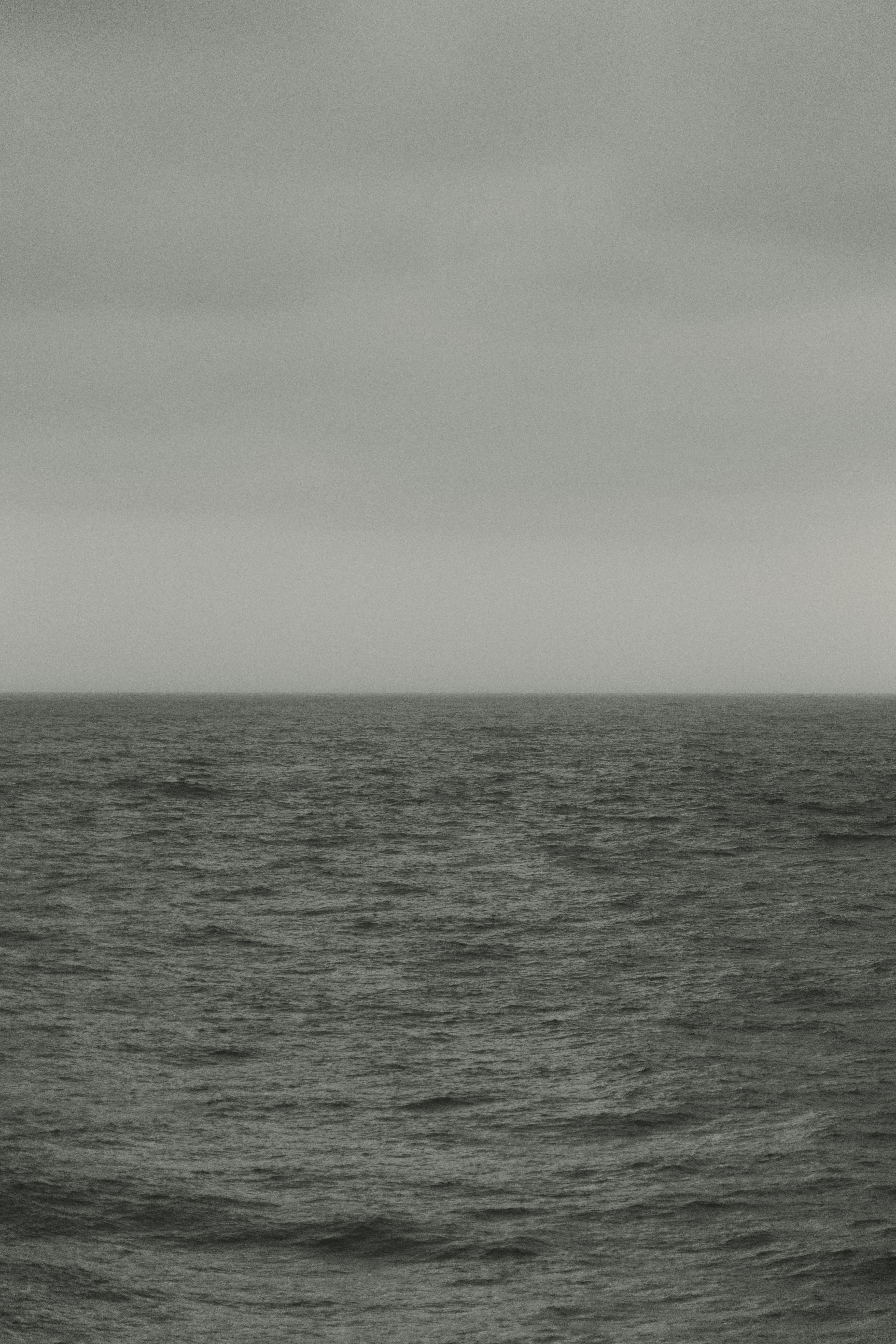 Um vasto oceano cinza encontra um céu nublado e nublado