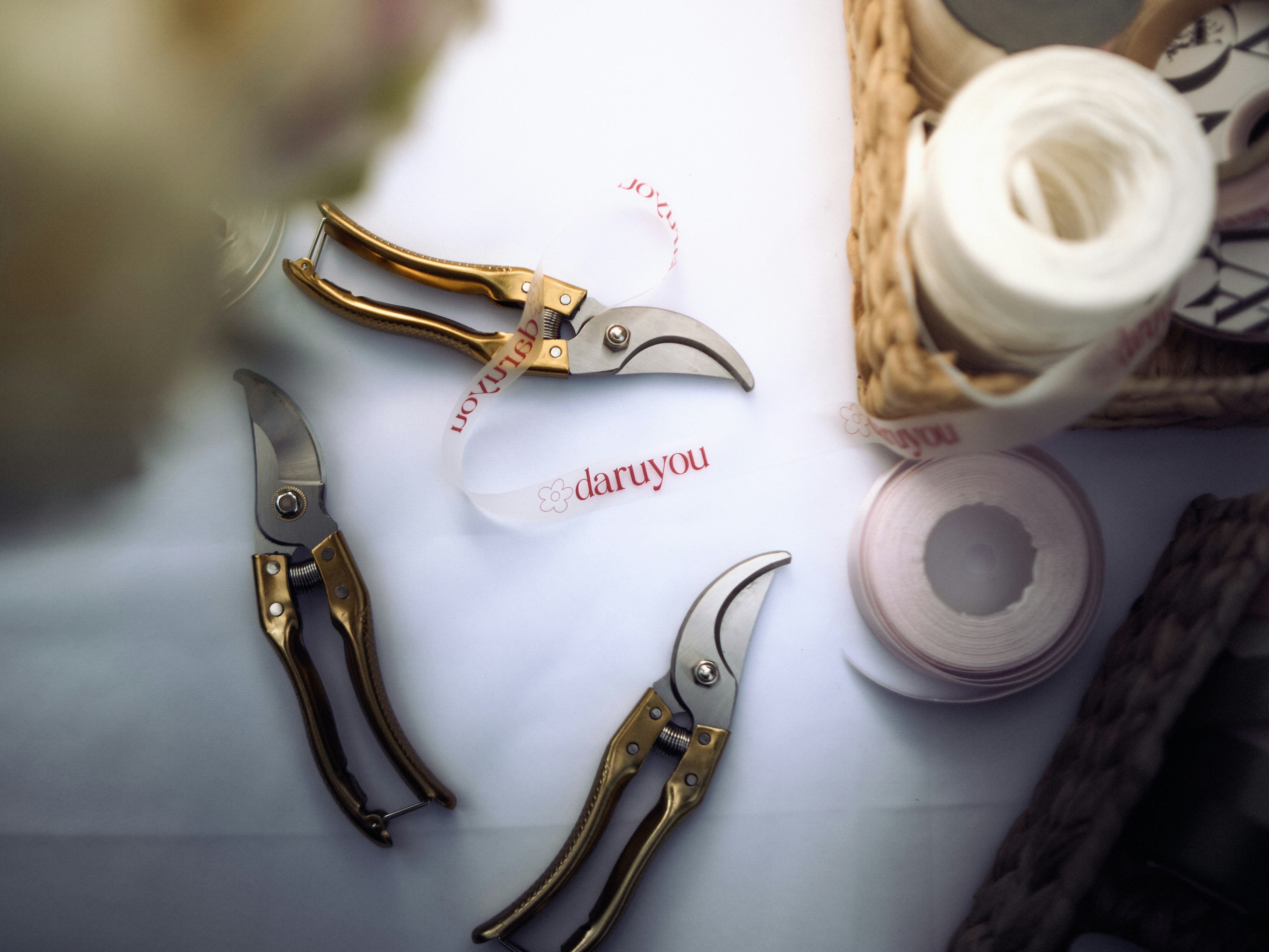 Floristry tools and ribbons arranged on a white table