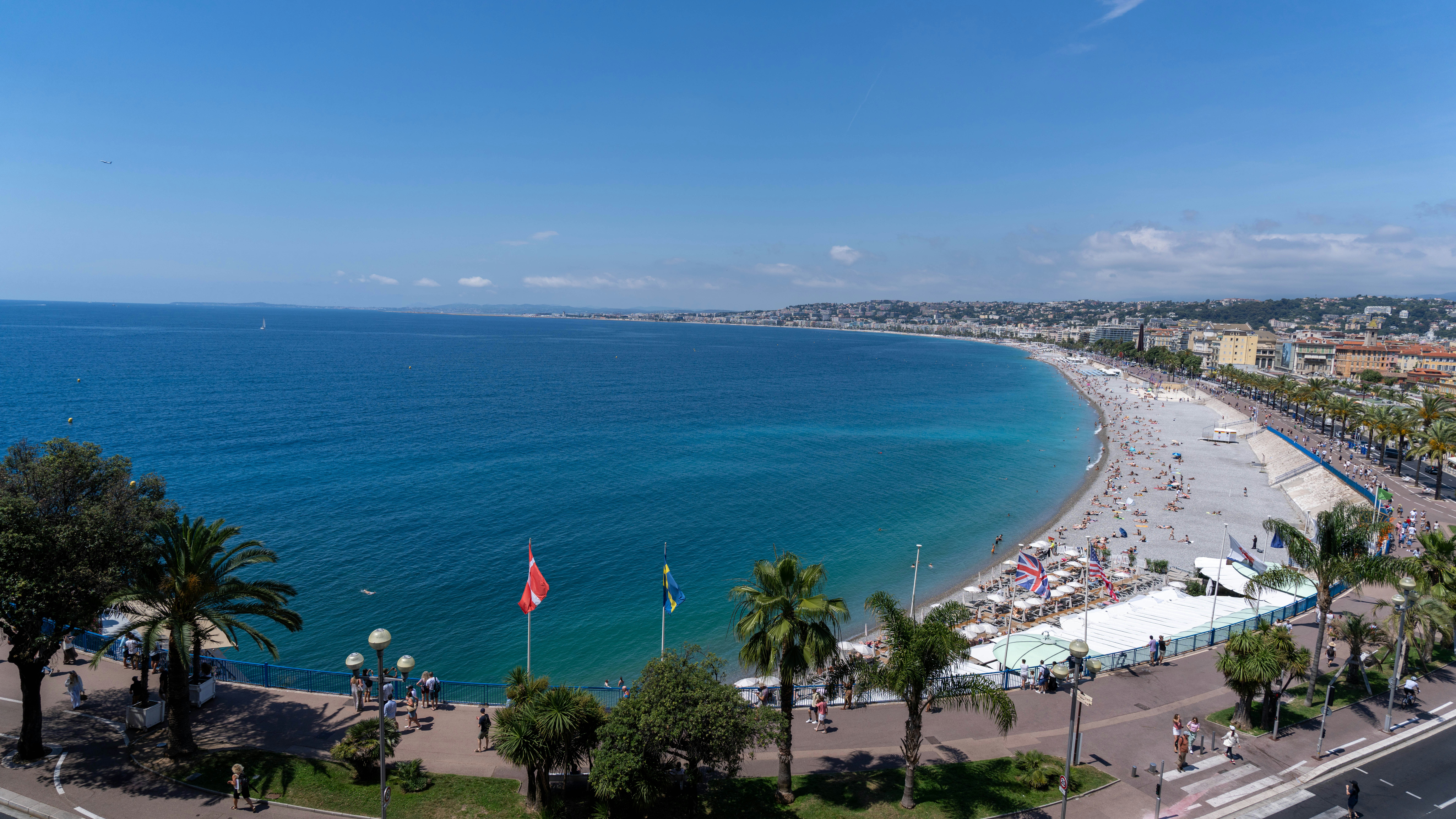 Vibrant city beach with blue ocean and clear sky.