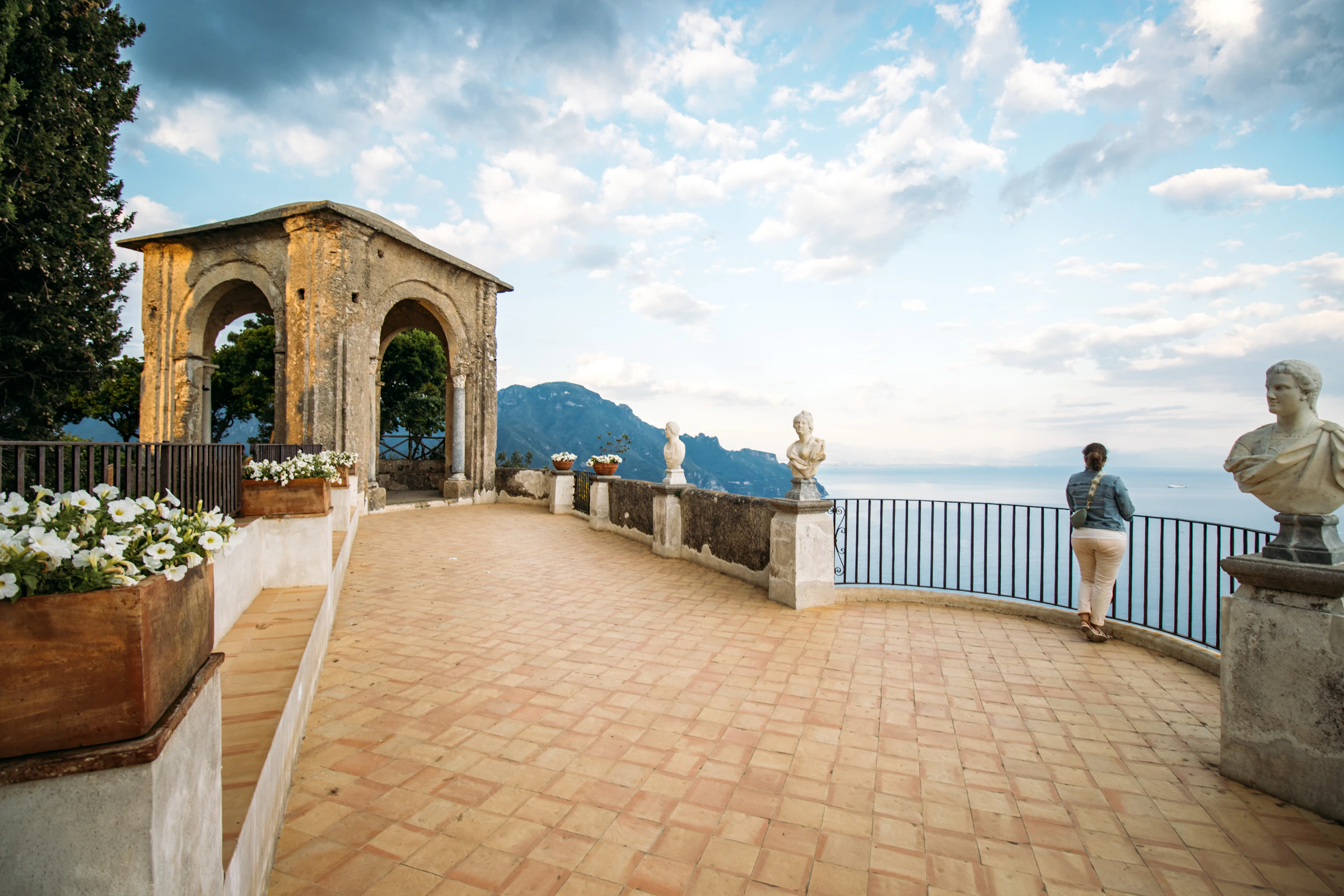 A traveler on the Terrace of Infinity at Villa Cimbrone in Ravello, gazing out over the Amalfi Coast.