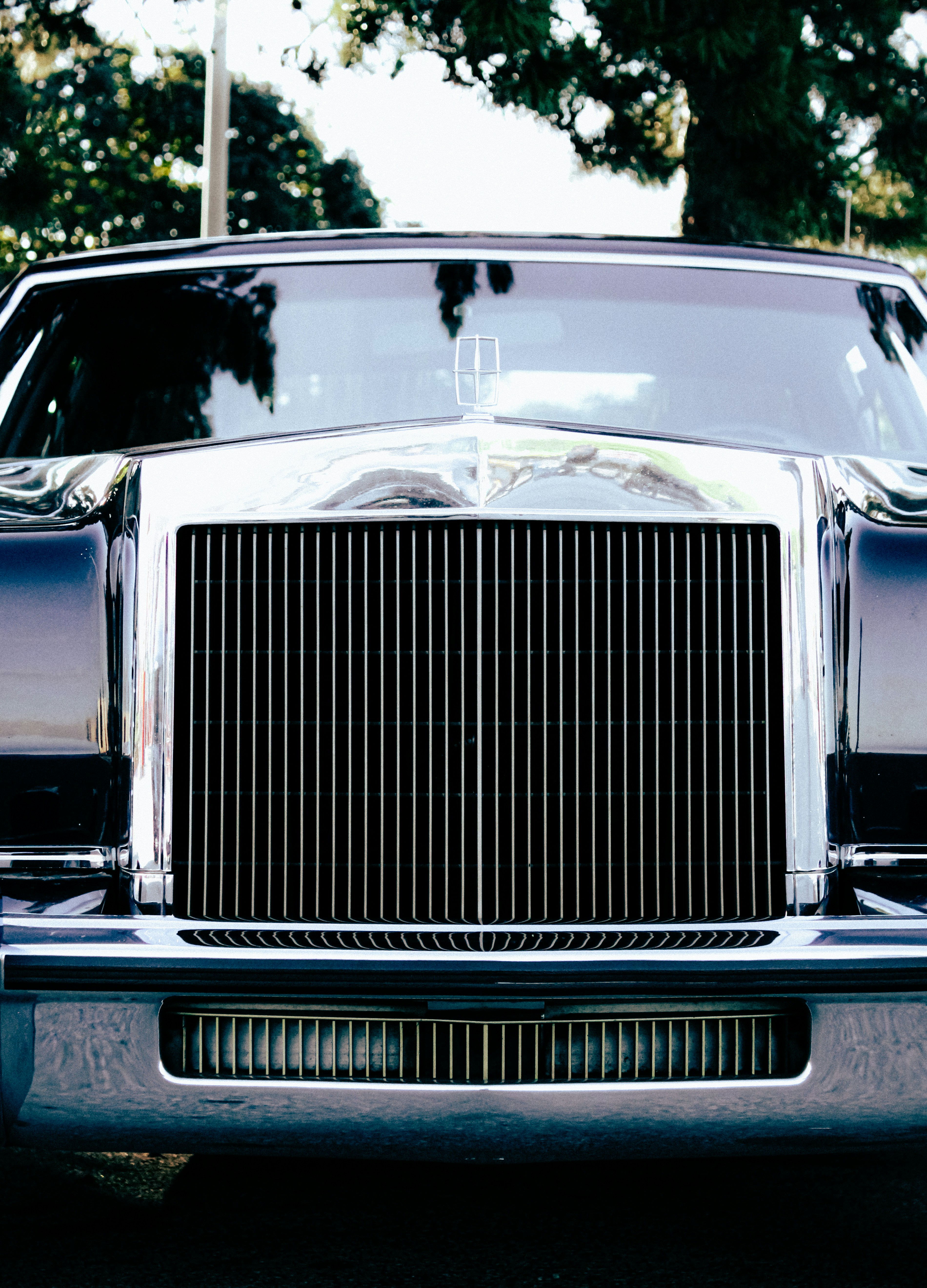 Classic dark car with a shiny chrome front grille.