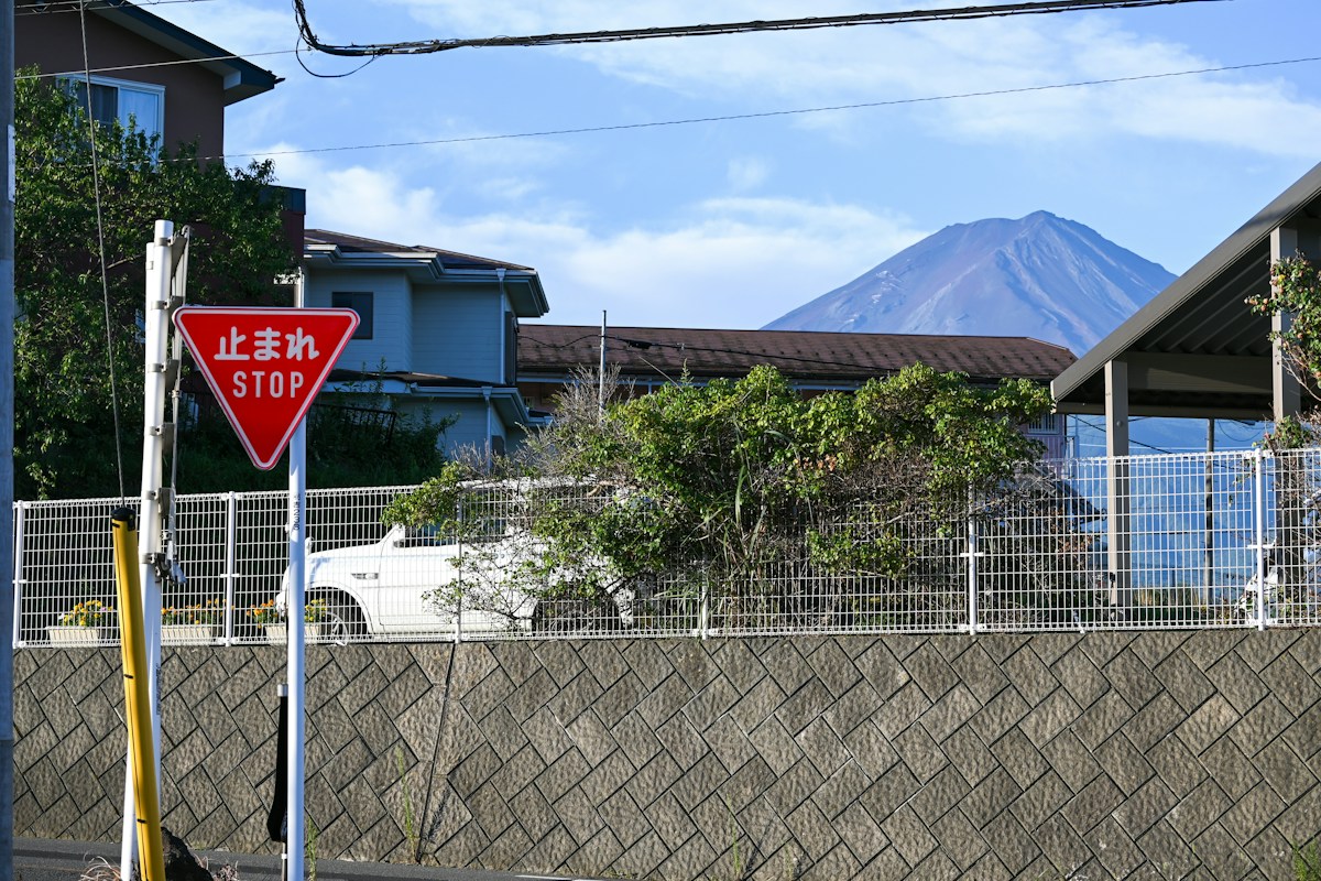 日本住宅區路口的止まれ停止標誌，遠方是富士山