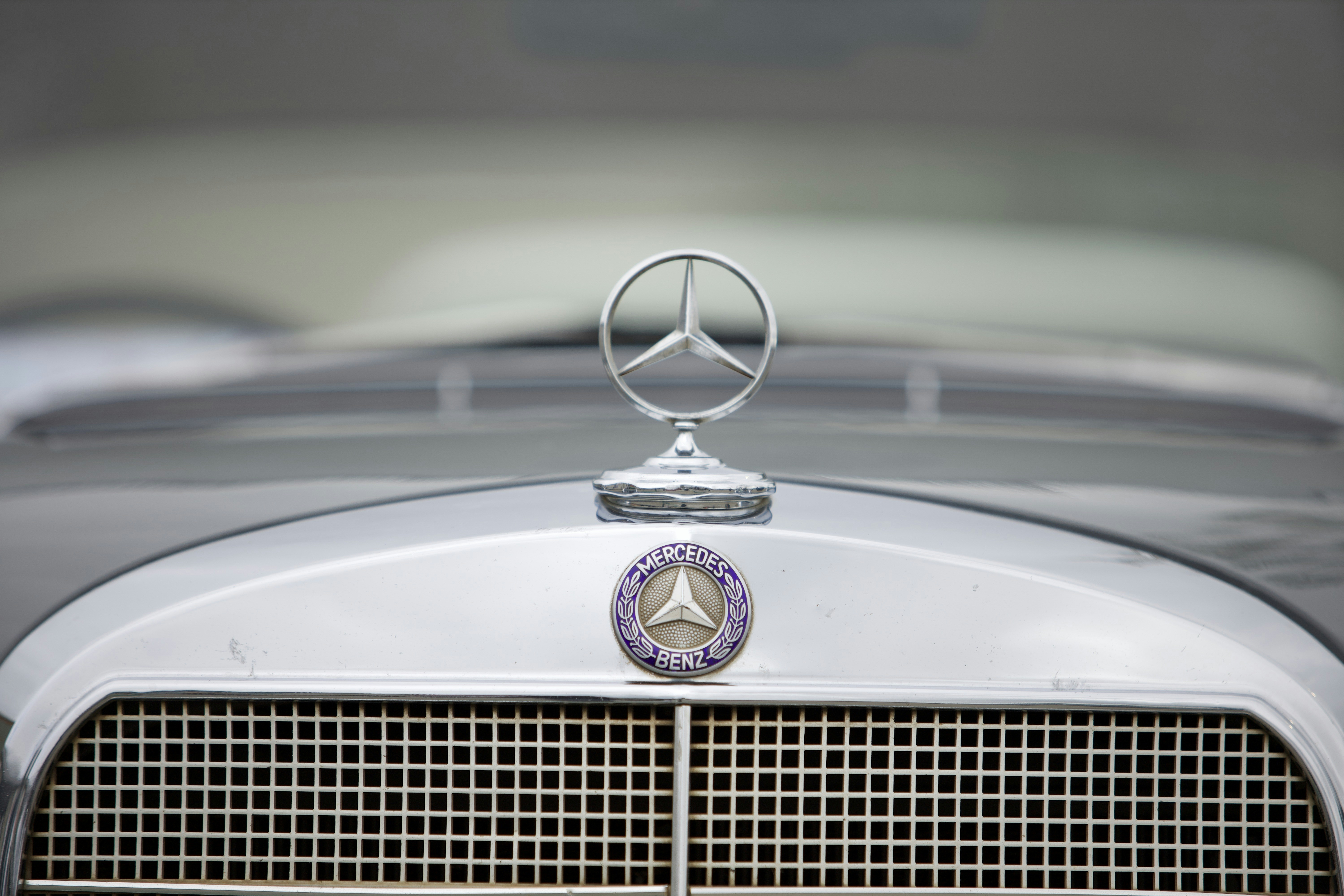 Mercedes-benz hood ornament and emblem on a car.