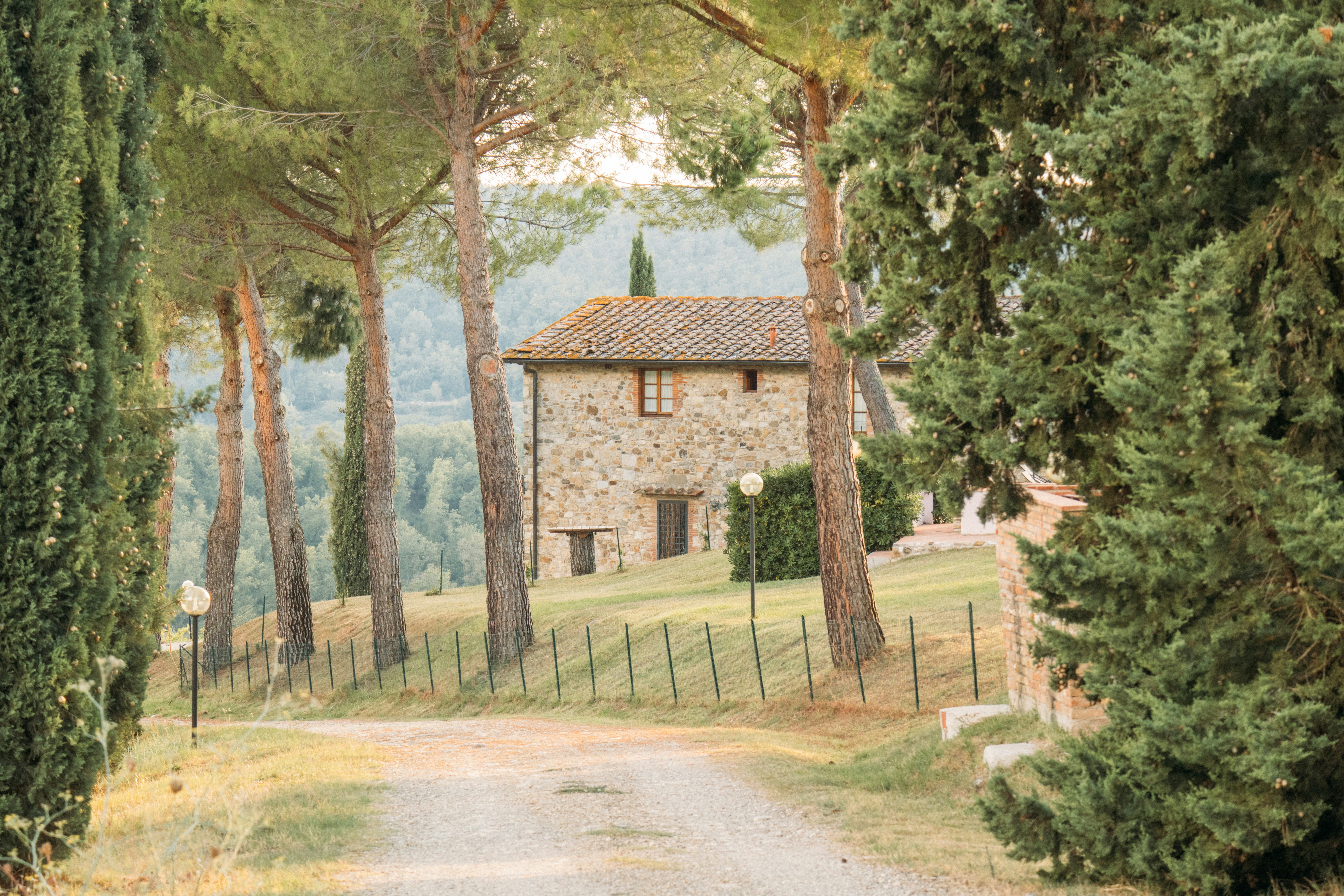 A stone farmhouse sits at the end of a gravel path.
