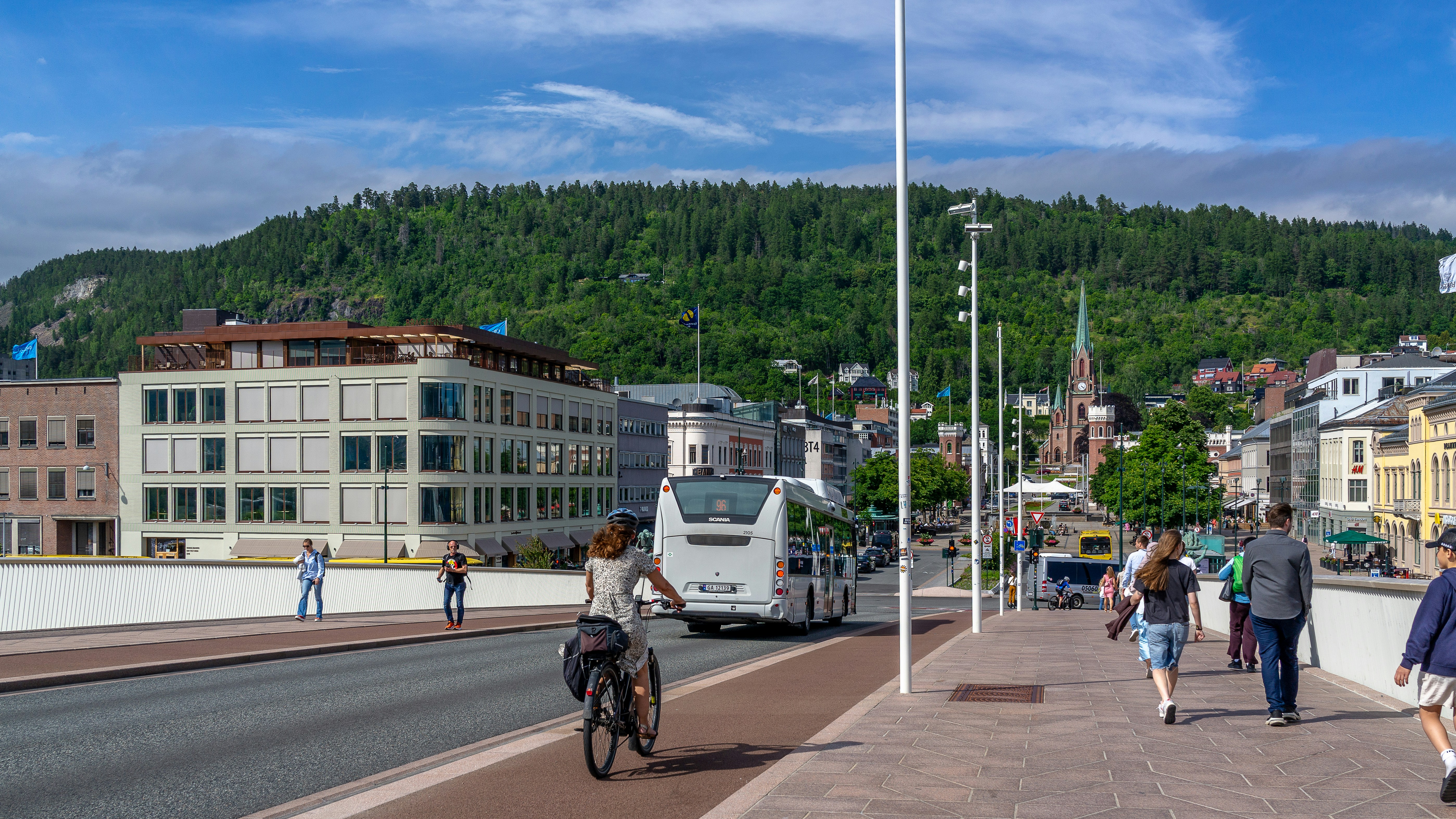Cyclist, bus and pedestrians on a bridge