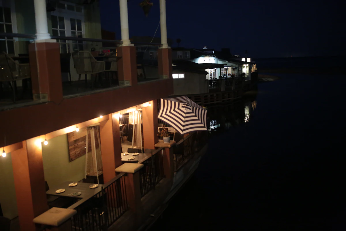 Waterside terrace after dark. Illustrative editorial image, not a photograph of The Quay Shed.