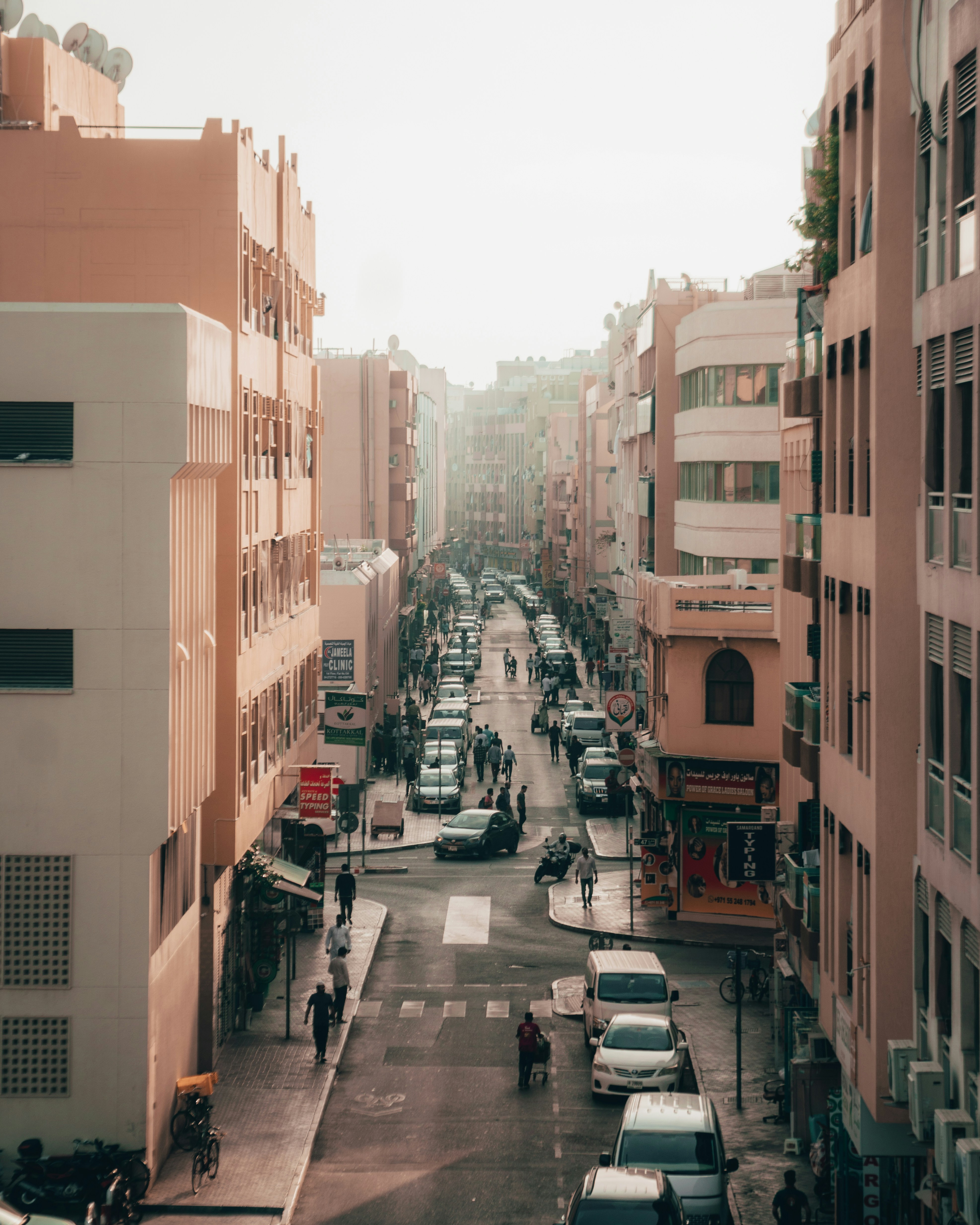 A busy city street lined with buildings, cars, and people.