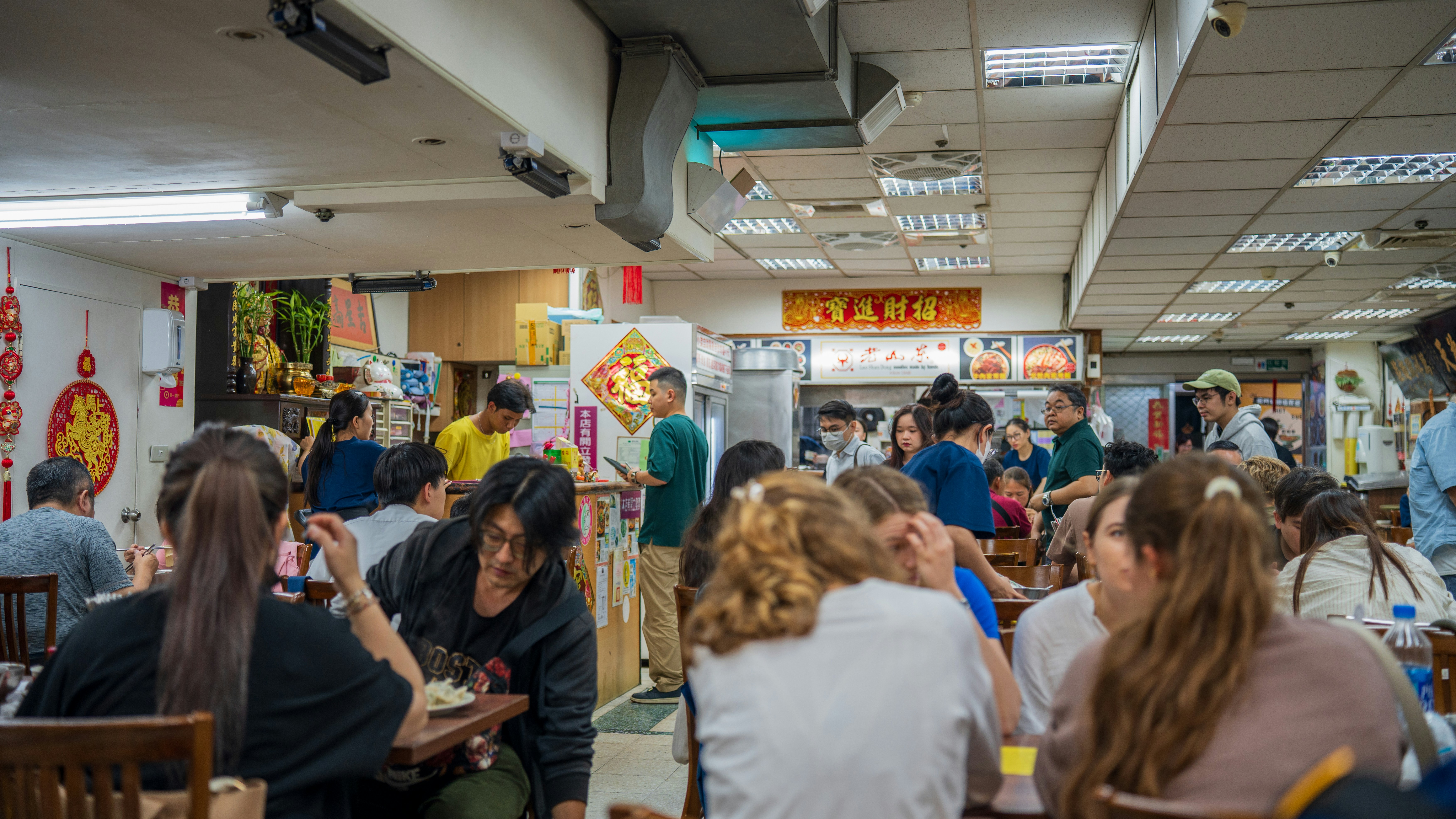 People eating in a busy indoor restaurant.