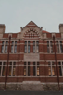 Historic red brick building with stone accents and many windows.
