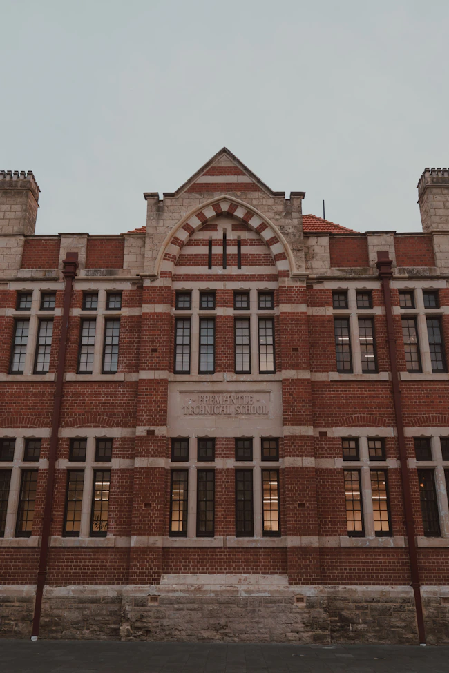 Historic red brick building with stone accents and many windows.