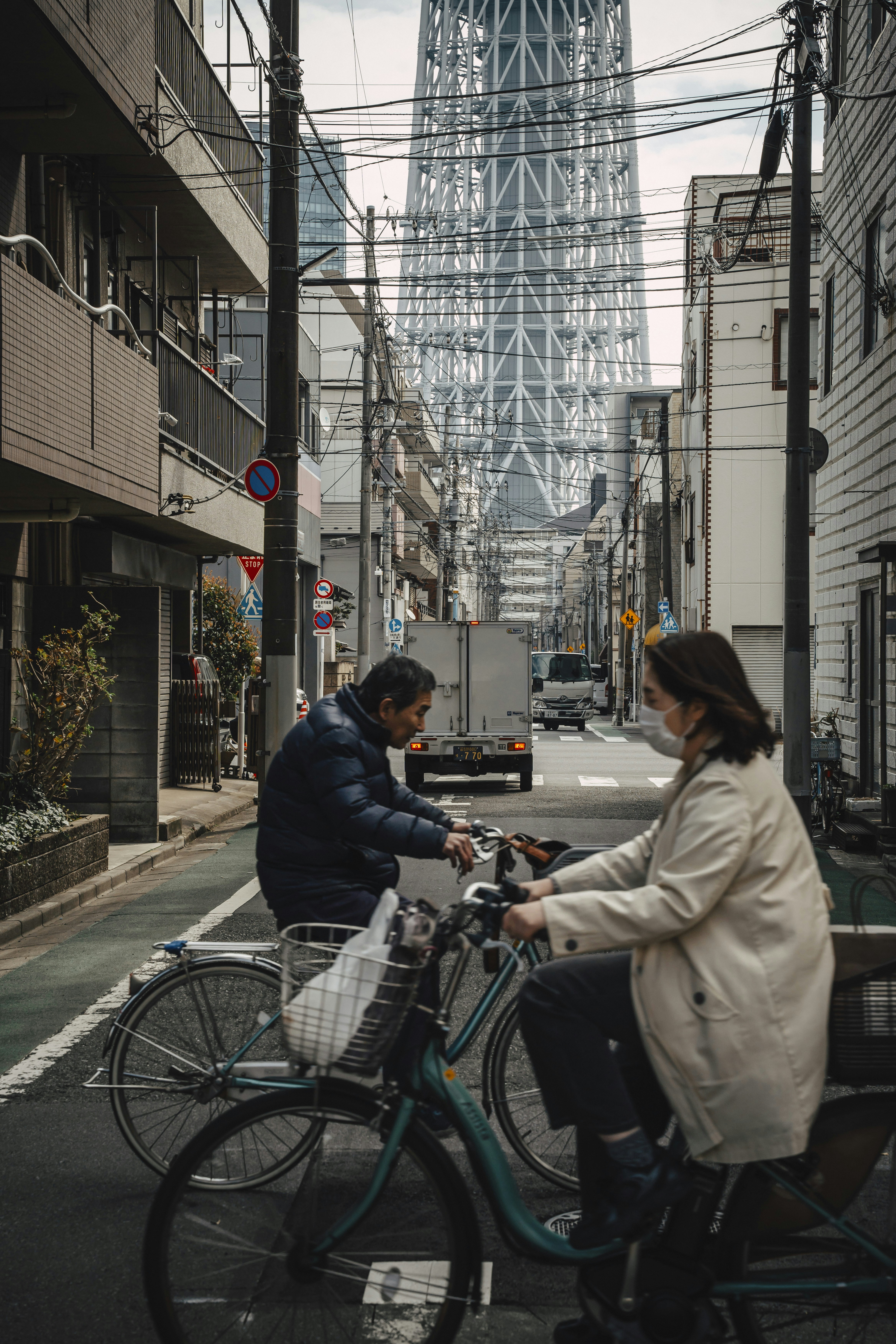 Cyclists on tokyo street beneath skytree