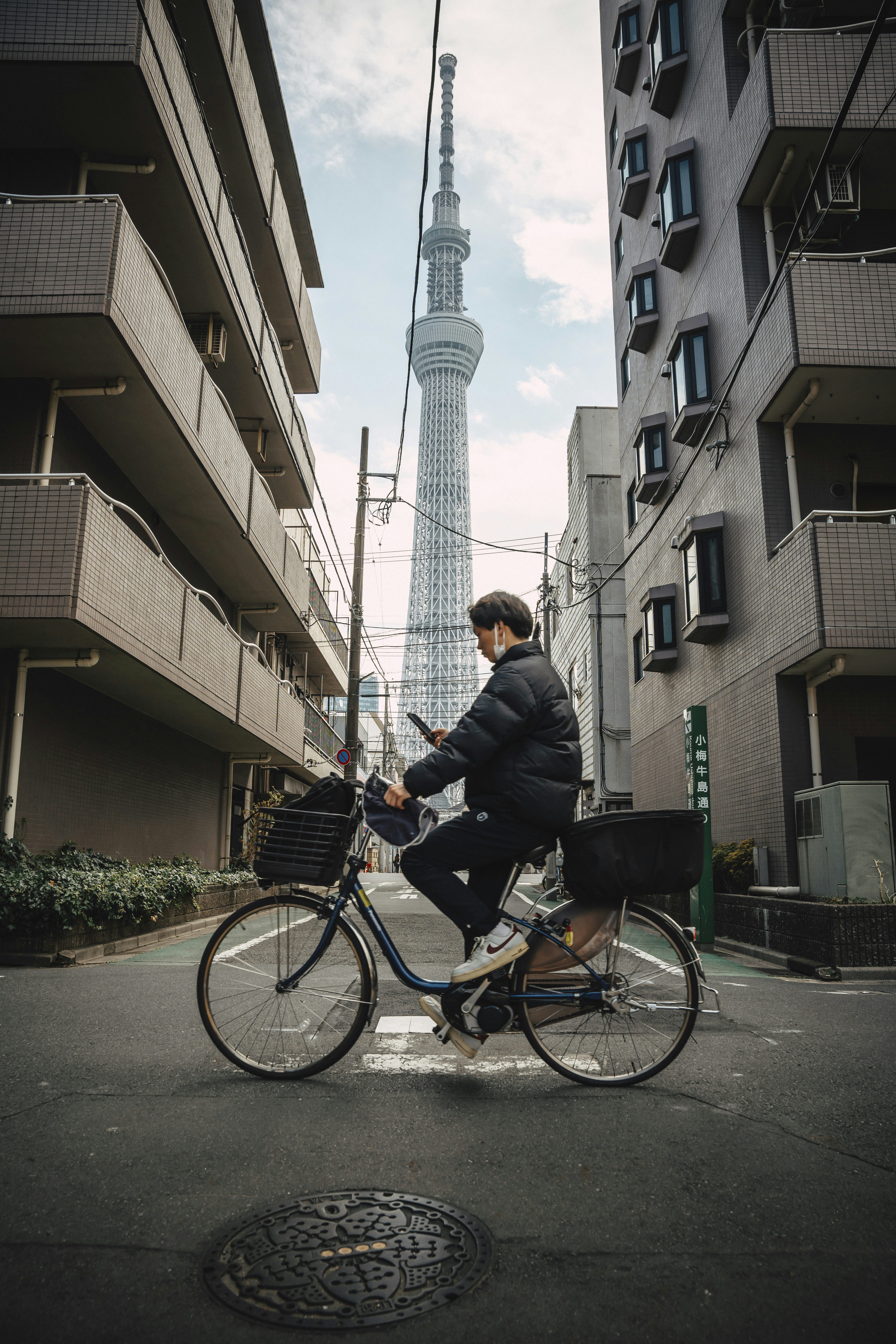 Man on bicycle looking at phone, tokyo skytree - 相关推荐
