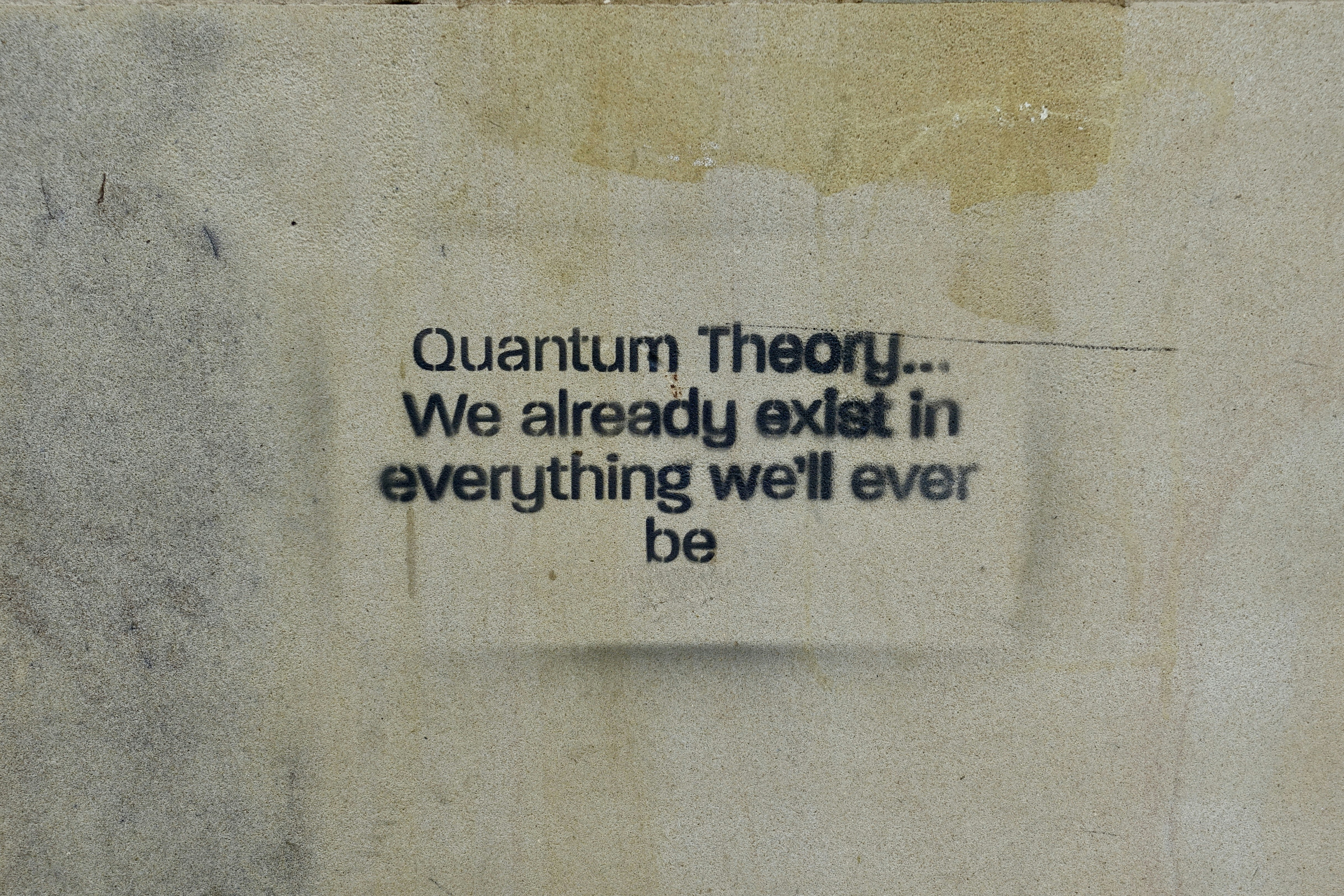 Quantum theory quote on a distressed, light-colored surface.