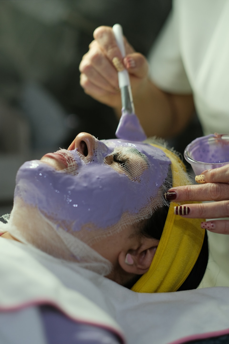 Woman having a facial mask applied in a private esthetician studio