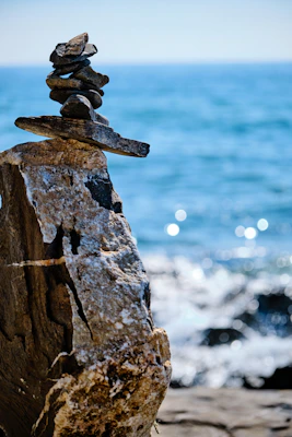 Steinmännchen auf der Kippe über dem Meer