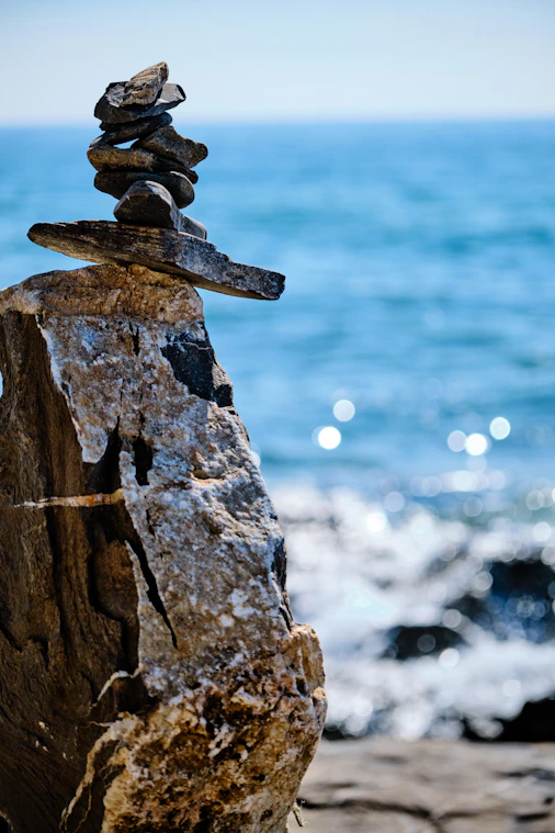 Steinmännchen auf der Kippe über dem Meer