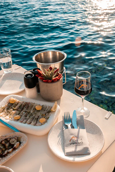 Seaside meal of grilled fish served with wine, evoking a Greek seafood taverna