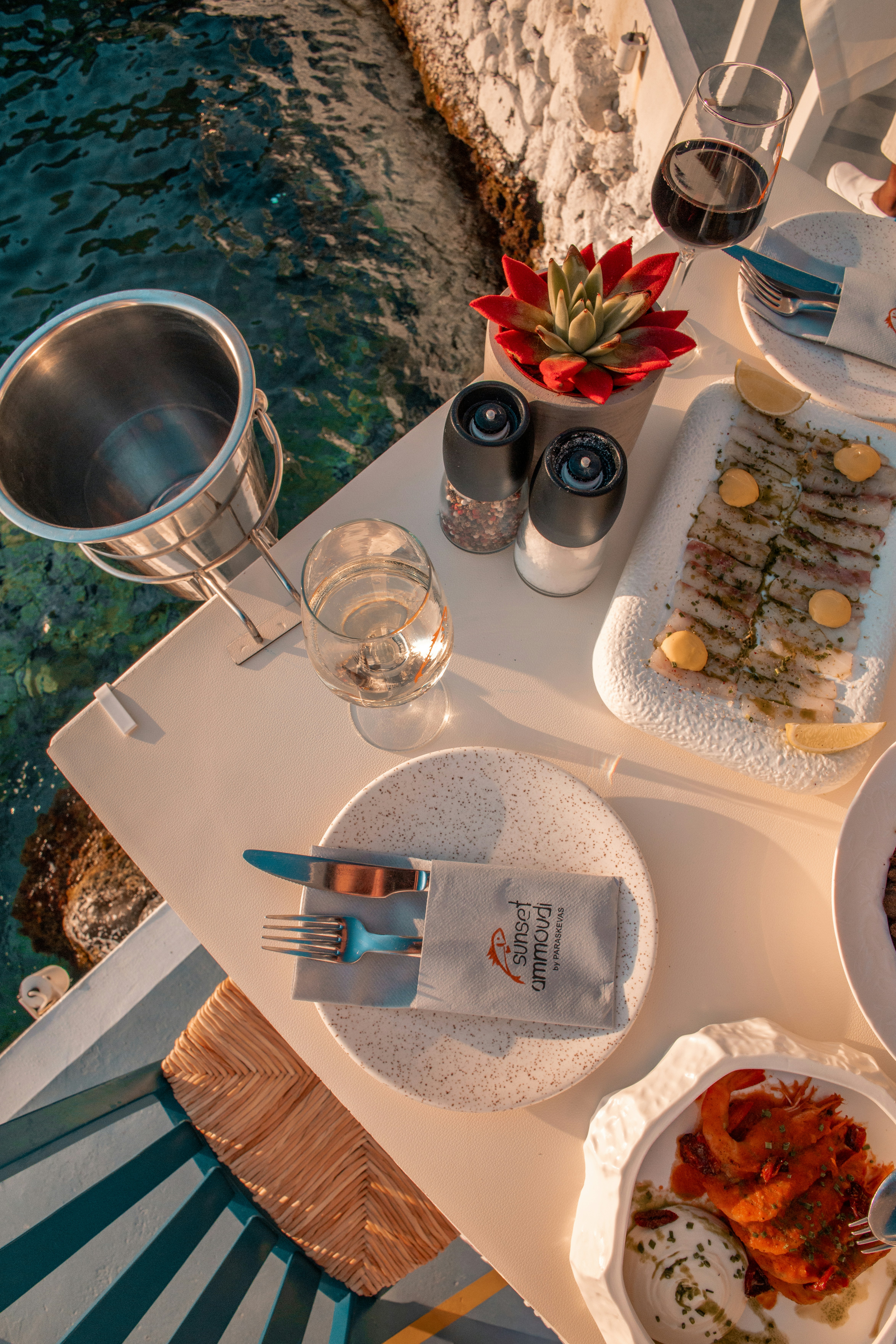 Seaside dining table with food and wine in fira