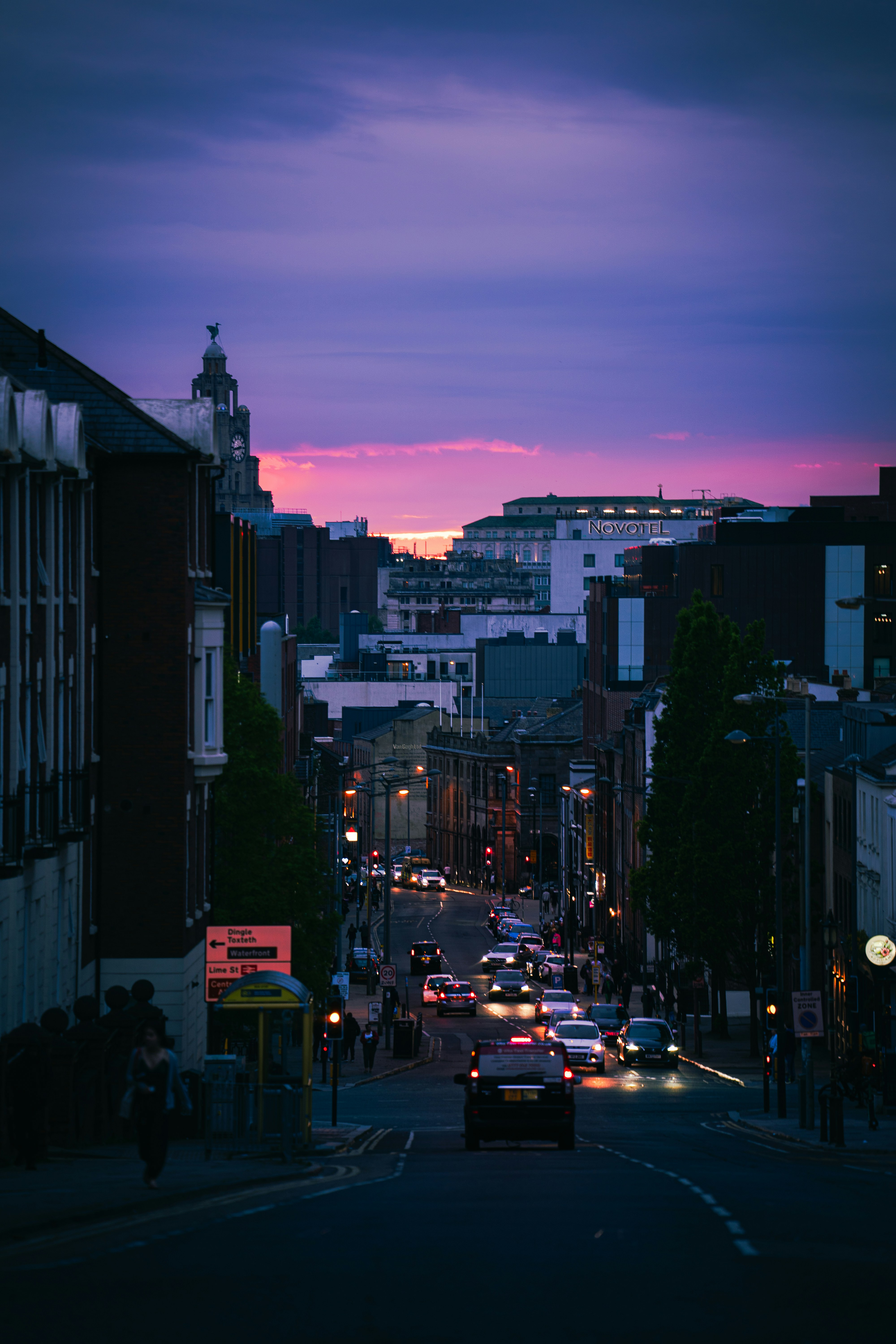 Urban street with cars and buildings at sunset