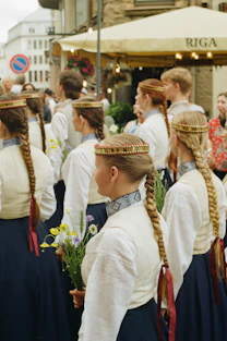 Young women in traditional attire with braided hair and wildflowers