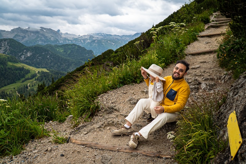 Father and child resting on a scenic mountain path.