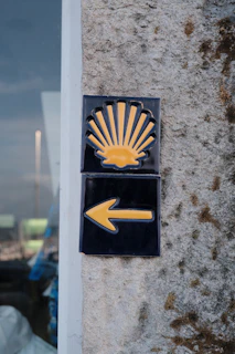 Camino de santiago scallop shell and arrow sign.
