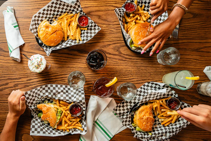 Burger baskets and fries across a busy table