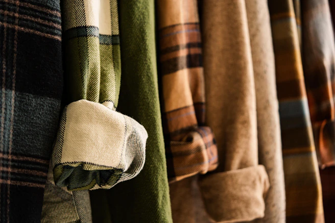 Warm flannel shirts with various patterns hanging.
