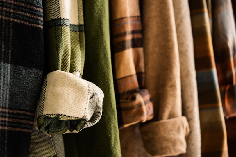 Warm flannel shirts with various patterns hanging.