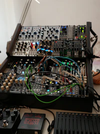 A patched modular synthesiser system wired across two racks in the Coldboot workshop