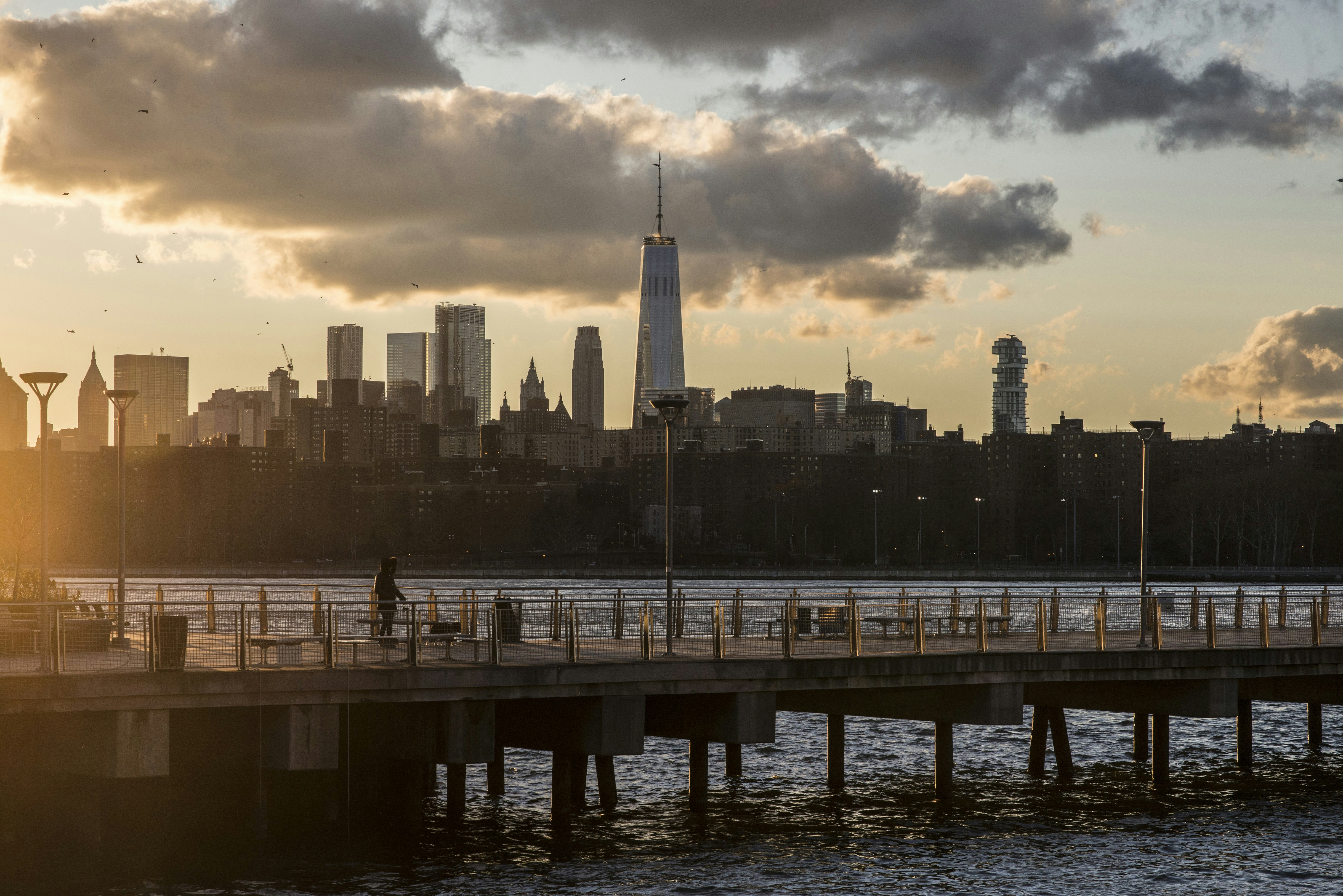 Cakrawala kota New York saat matahari terbenam dengan dermaga.