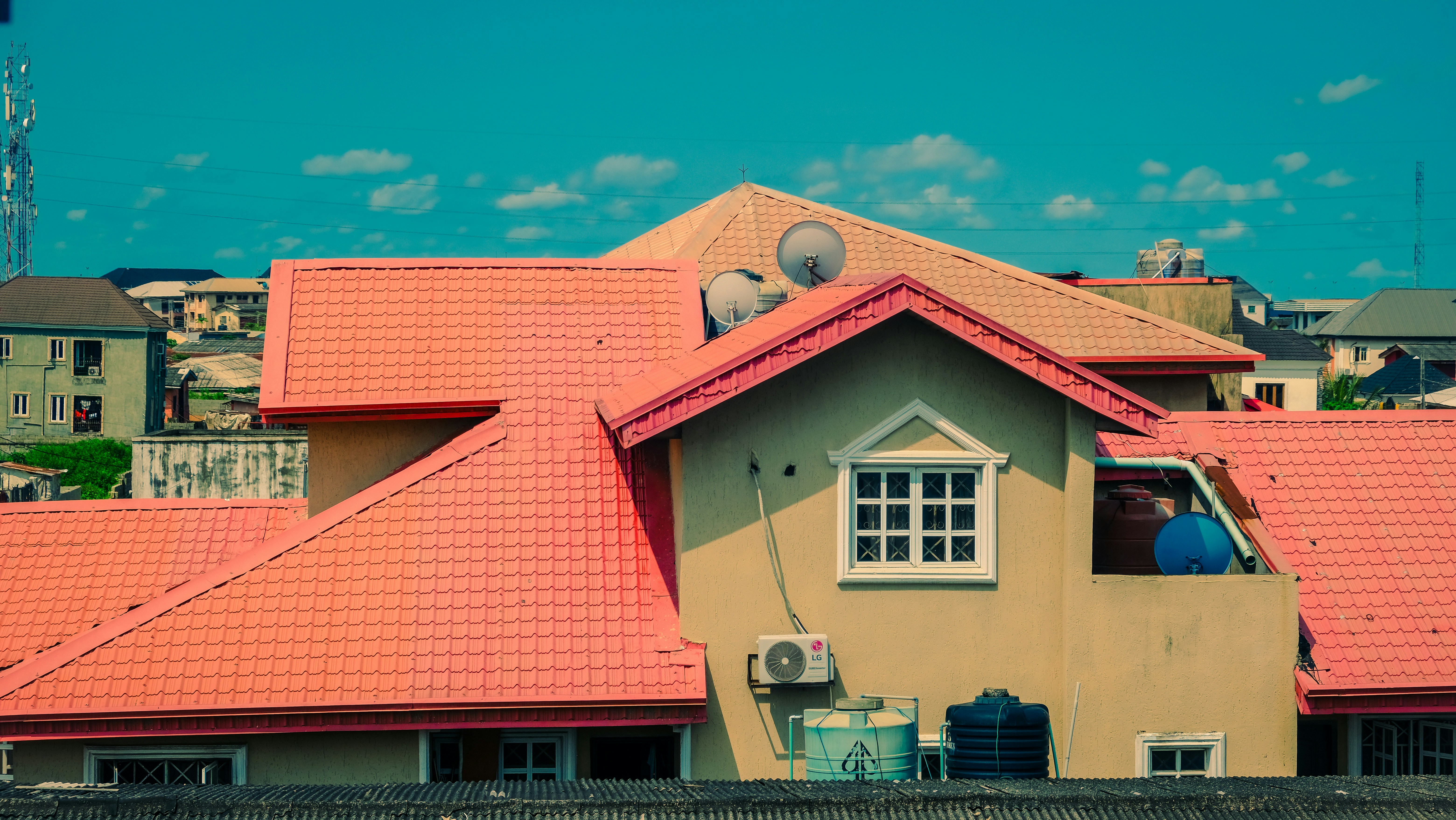 Orange-red tiled roofs on buildings under a clear blue sky.