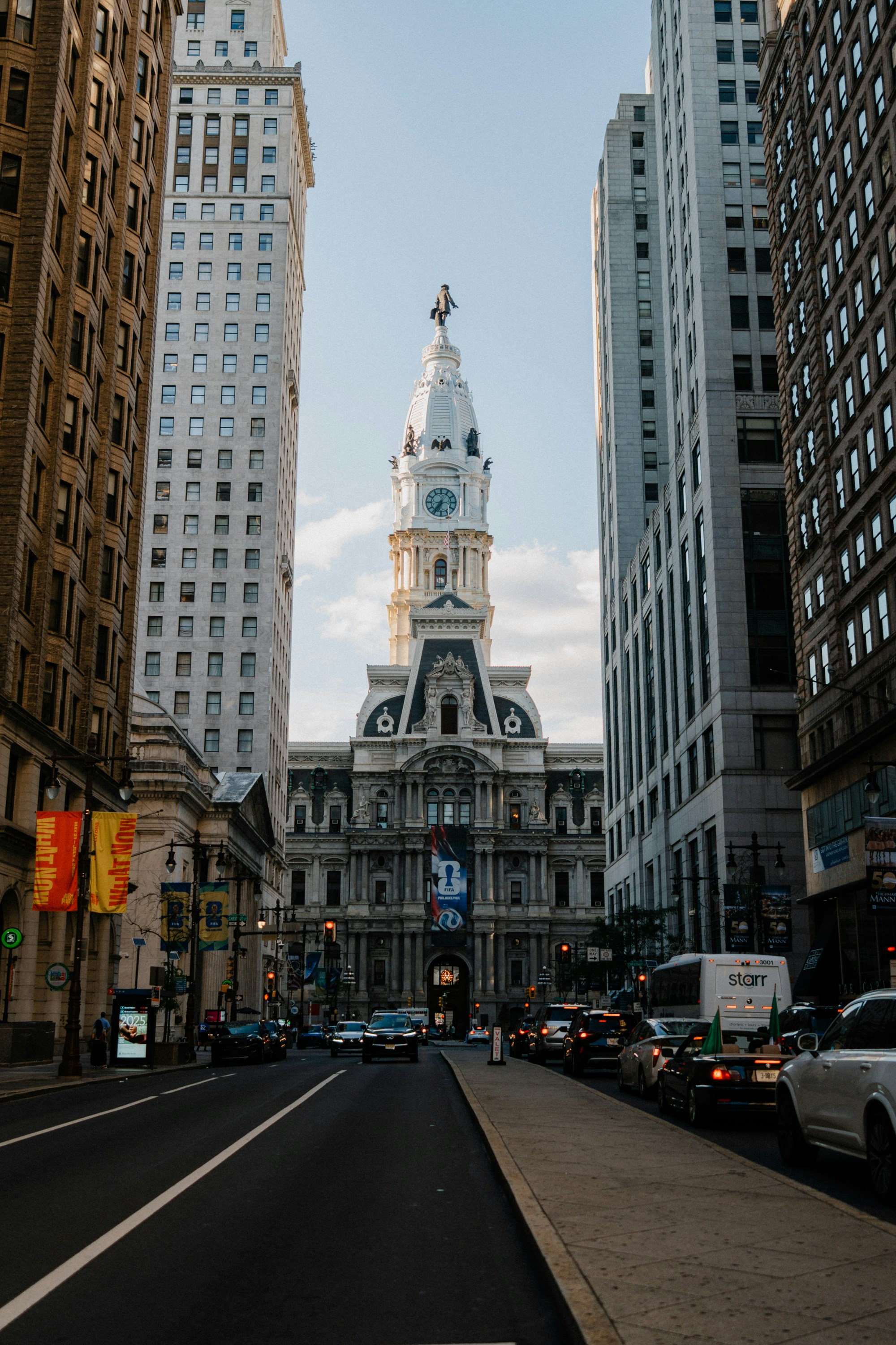 Grand philadelphia city hall dominates a bustling city street.